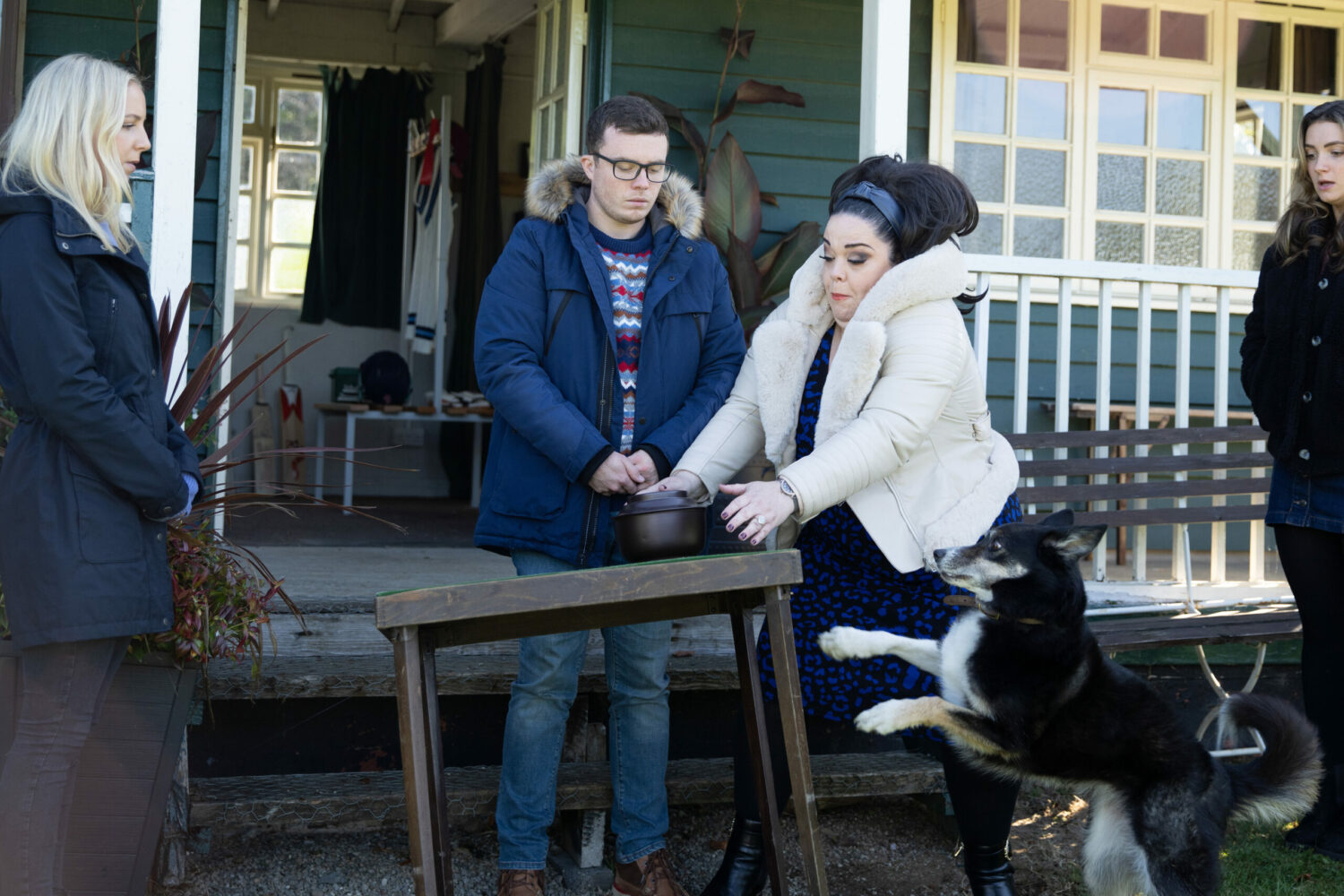 Chip leaps at the table with Liv's ashes as Mandy tries to help. Vinny, Belle and Gabby watch in Emmerdale spoilers