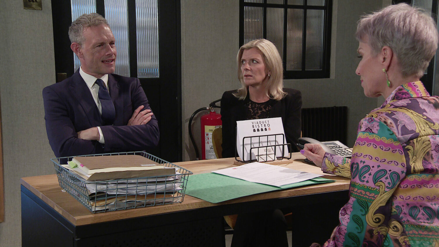 Nick and Leanne sat behind a desk in Coronation Street