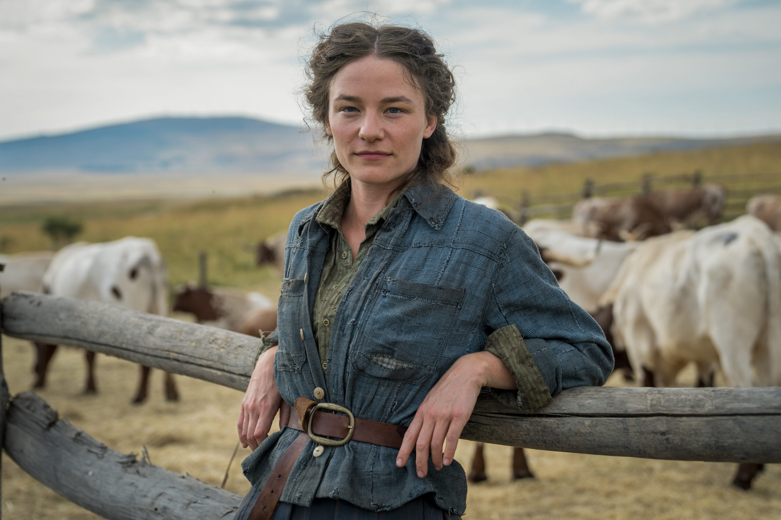 Martha Myers leans against a fence in The English