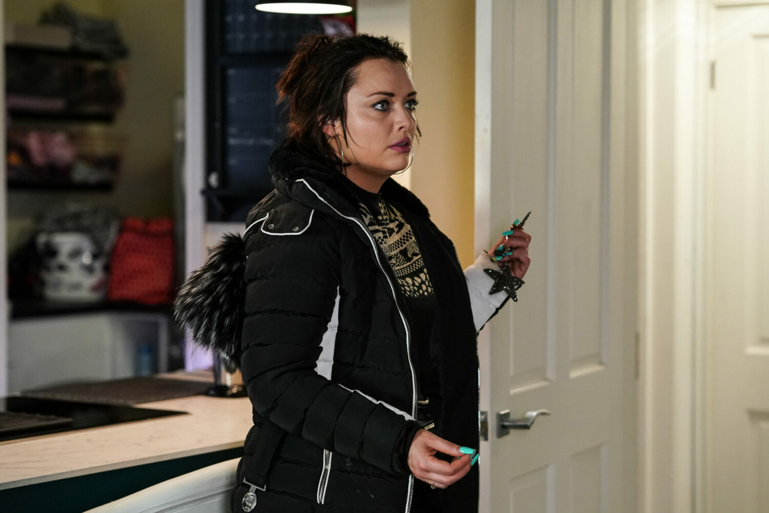 EastEnders' Whitney looks taken aback as she holds her keys in the kitchen