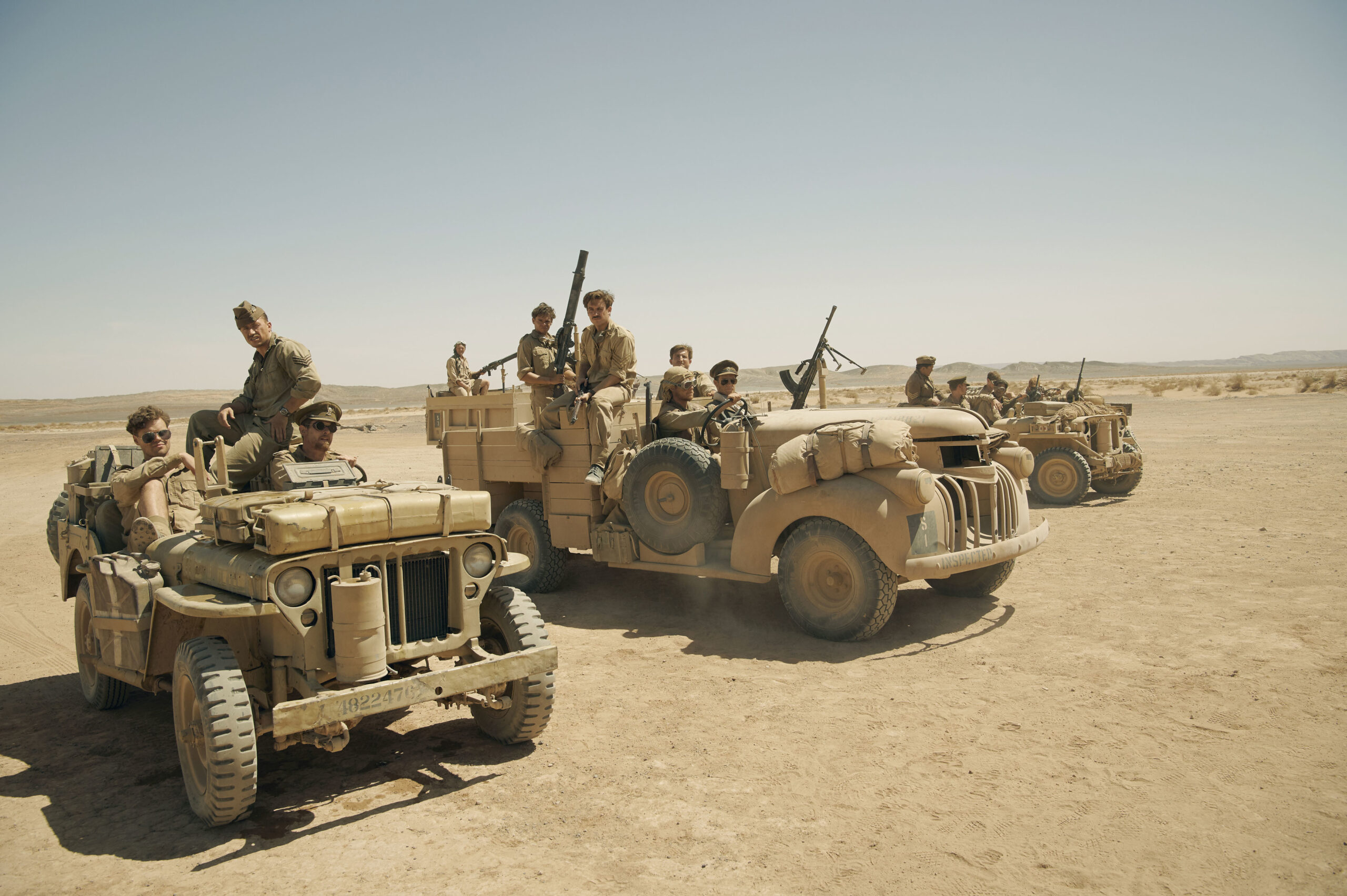 The cast of SAS Rogue Heroes driving in Jeeps