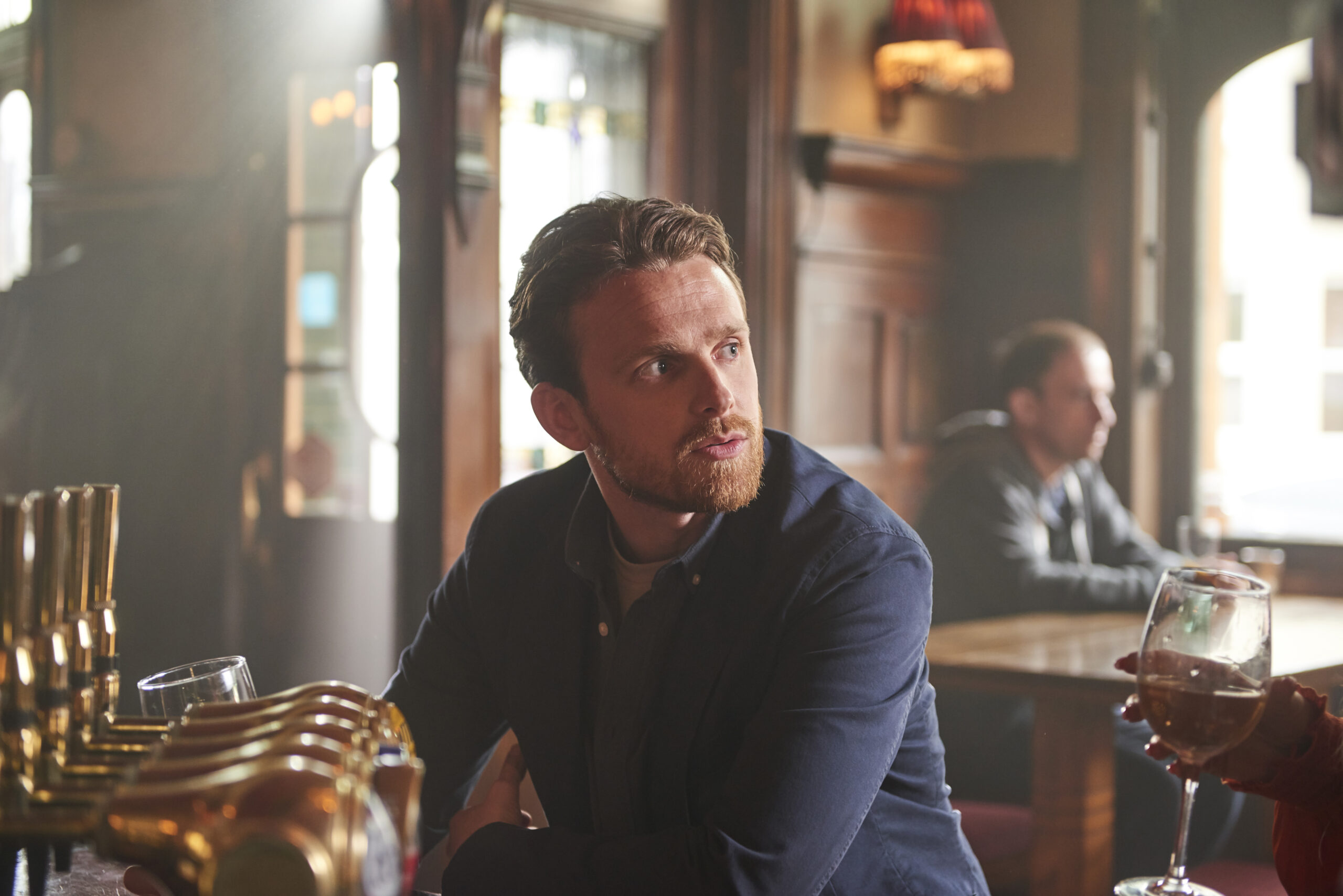 Joey Molloy looks up at Rosie in a bar with a frown