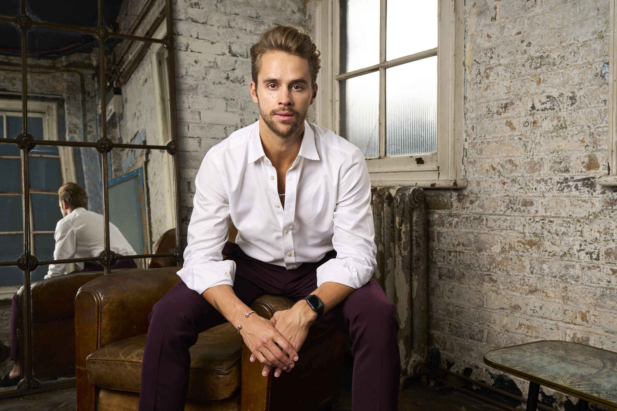 Julius Cowdrey posing on a chair in Made In Chelsea