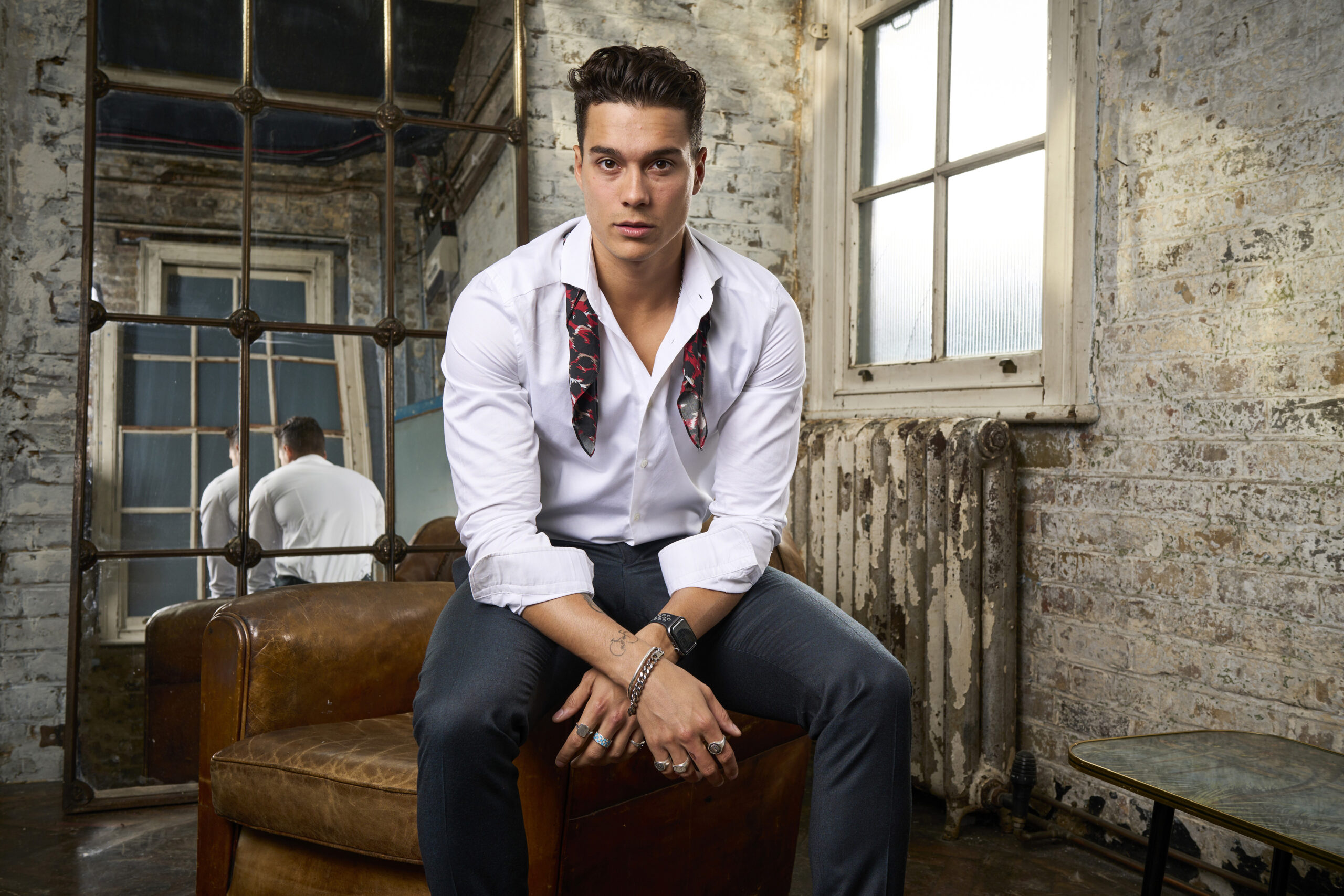 Miles posing on a chair in Made In Chelsea 