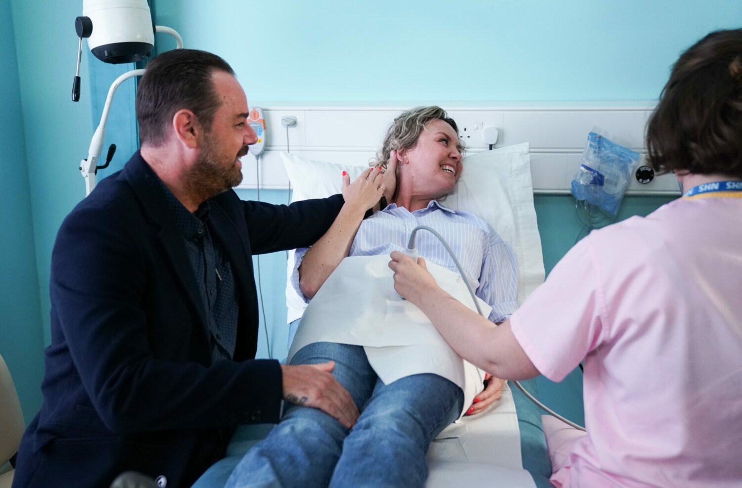 Mick smiling with Janine at the baby scan in EastEnders