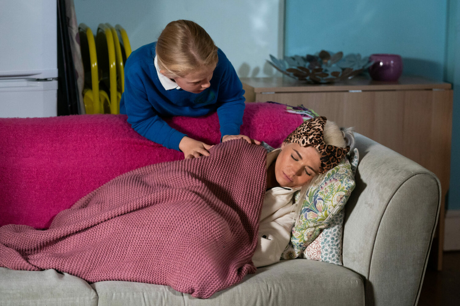Lexi looks over Lola who is asleep on the sofa following radiotherapy