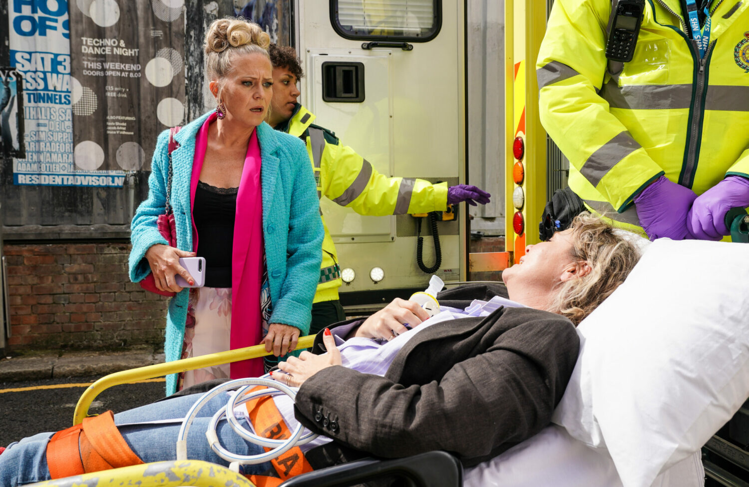 Linda talks to Janine as she is put in the back of an ambulance by a paramedic on EastEnders