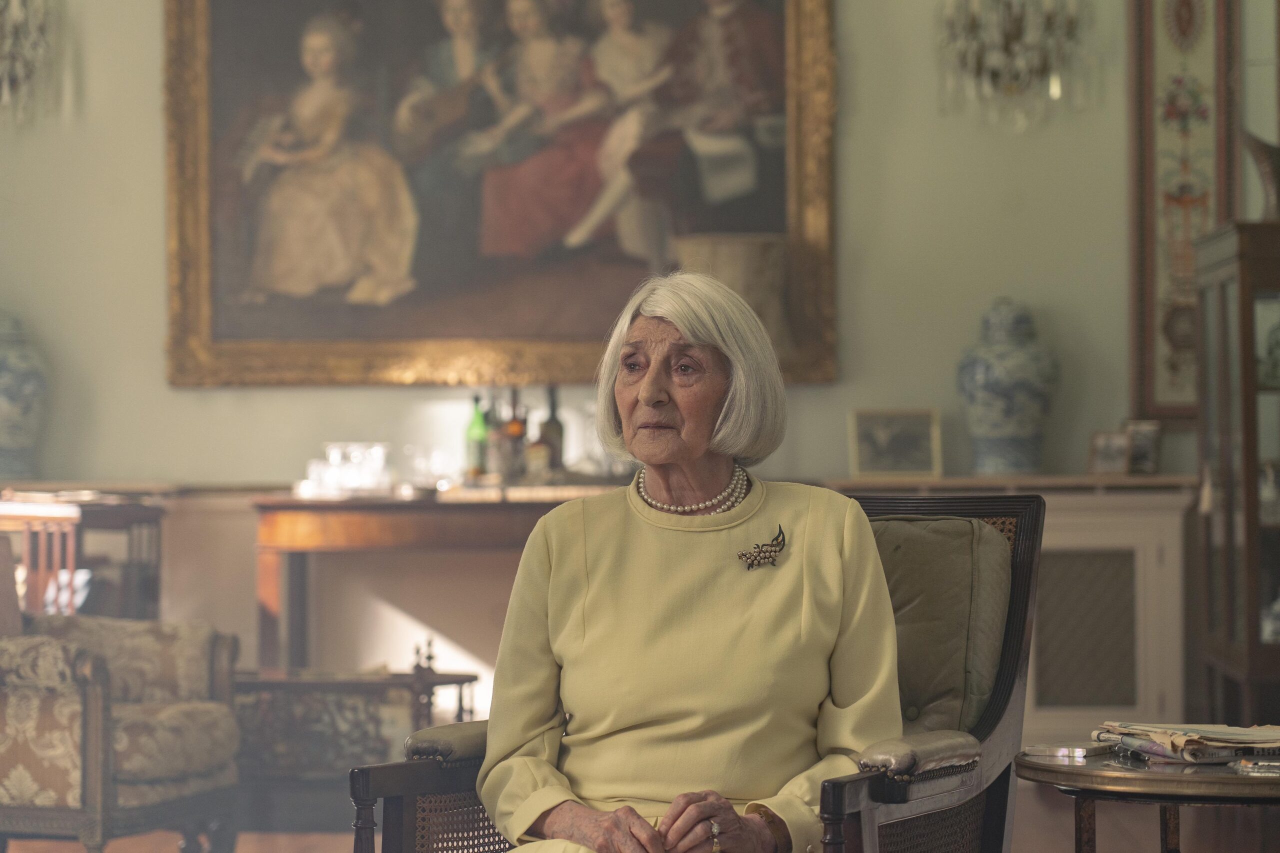 Lady Levina sits on a chair in a grand room