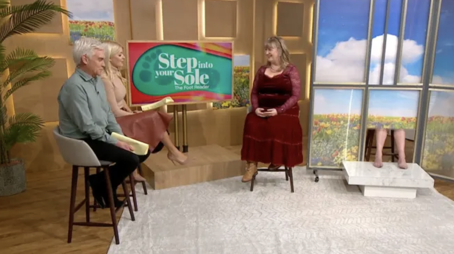 Phil and Holly speaking to guest alongside Gyles' feet on This Morning today