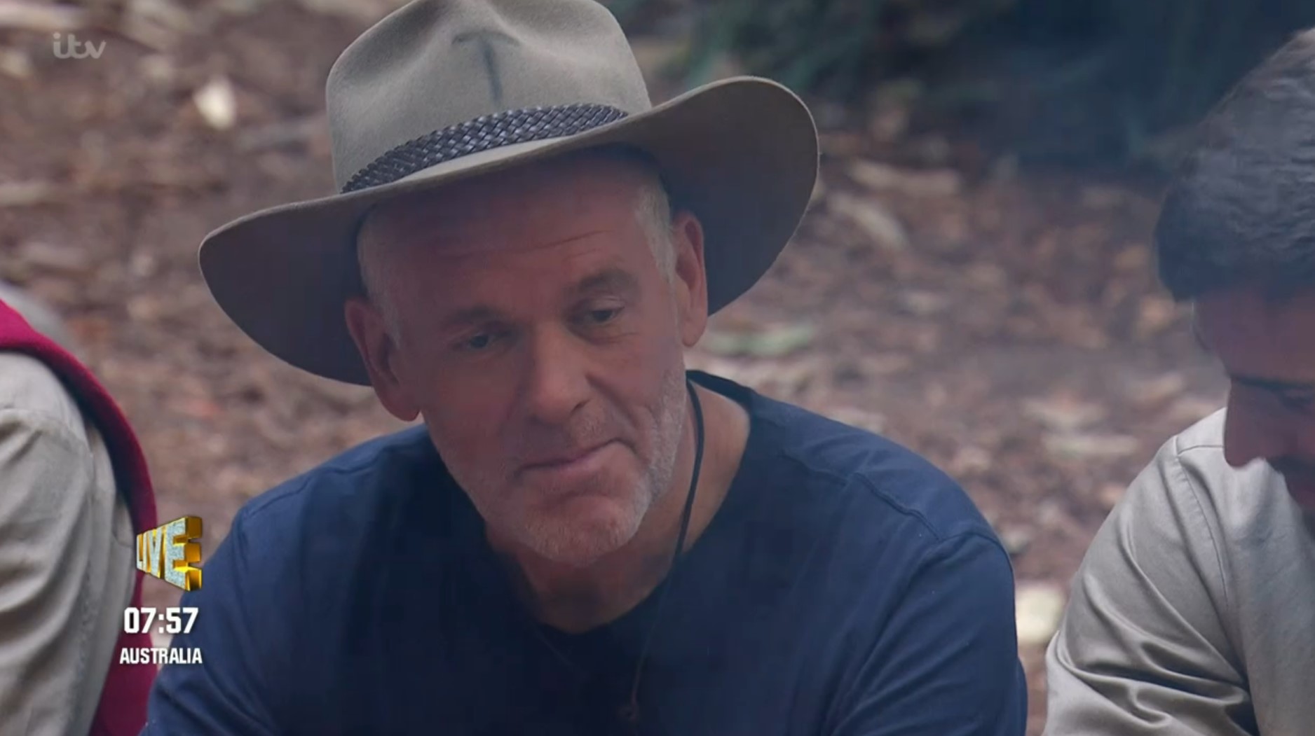 Chris Moyles smiles smugly in his hat on I'm A Celebrity