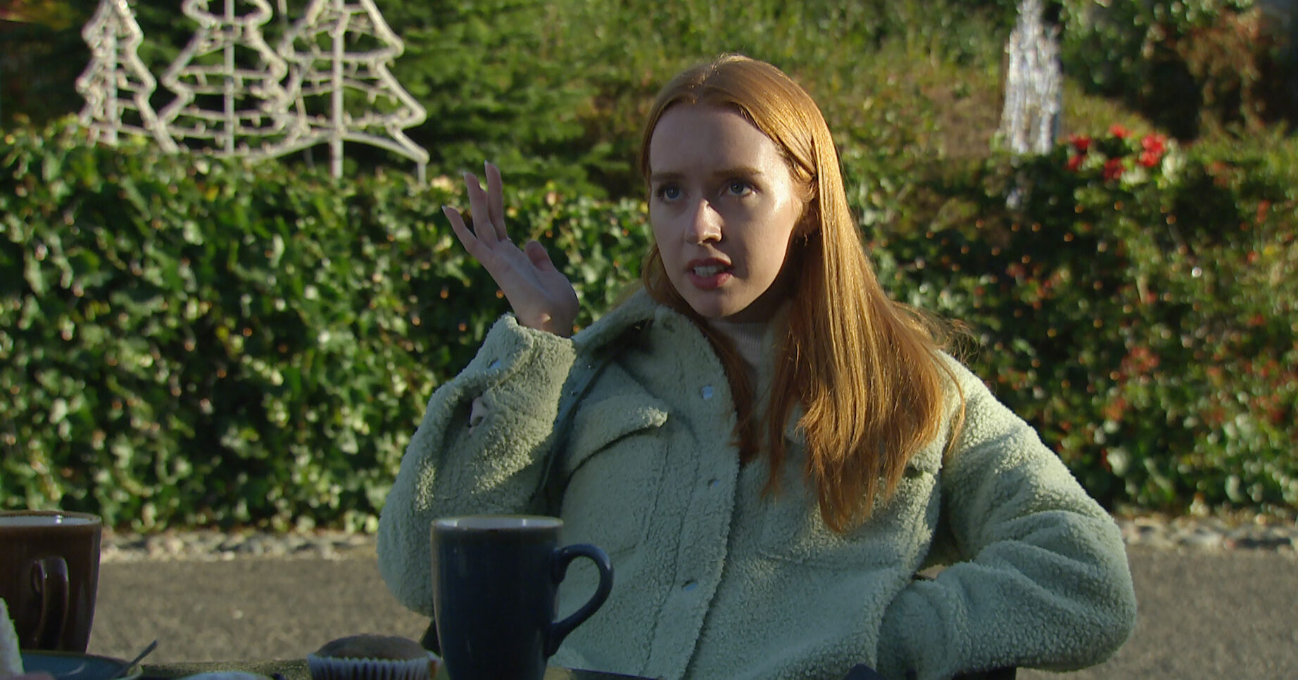 Chloe in Emmerdale throws her hand in the air as she announces she's pregnant