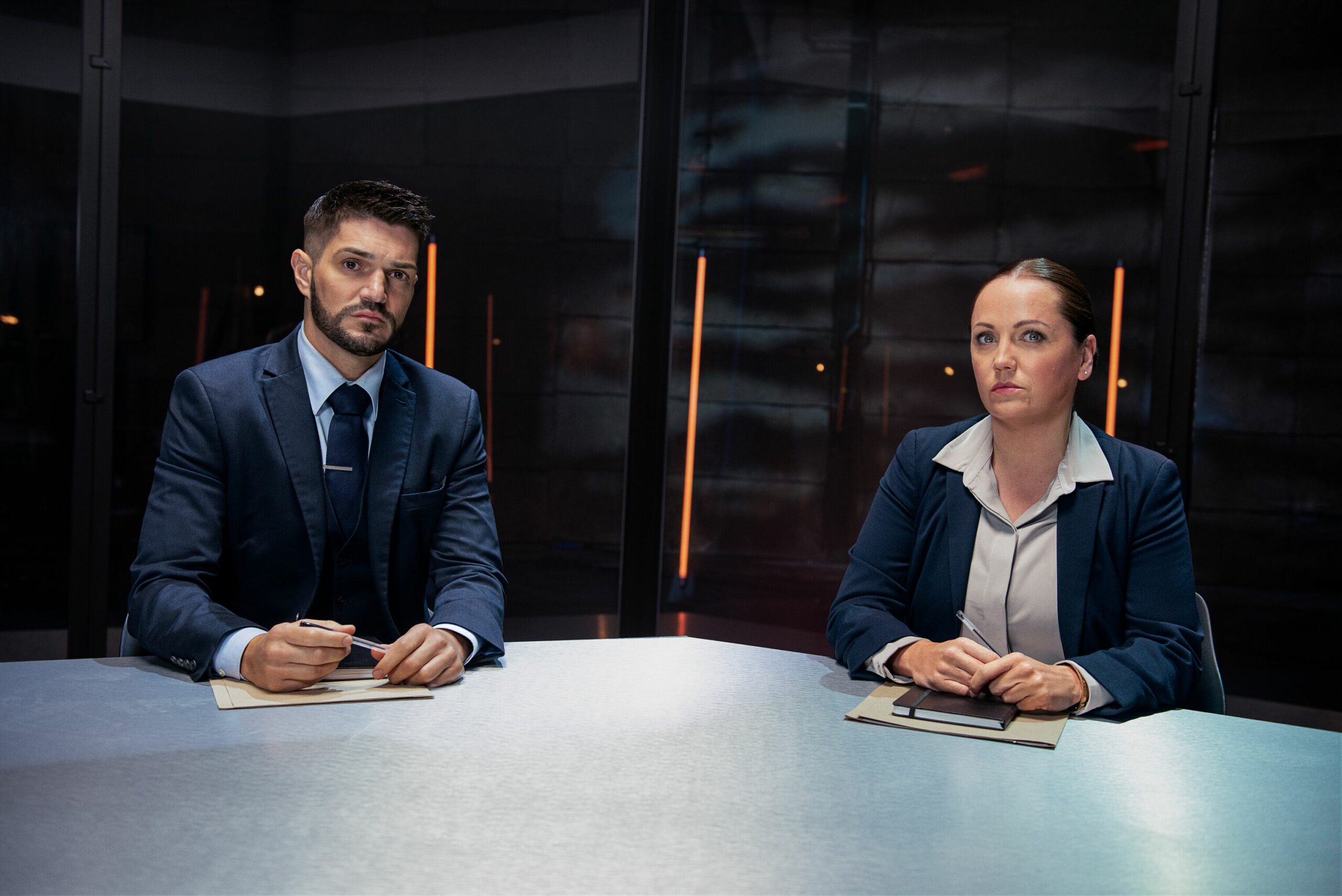 Interrogators Craig Stevens and Danni Brooke sitting at the table