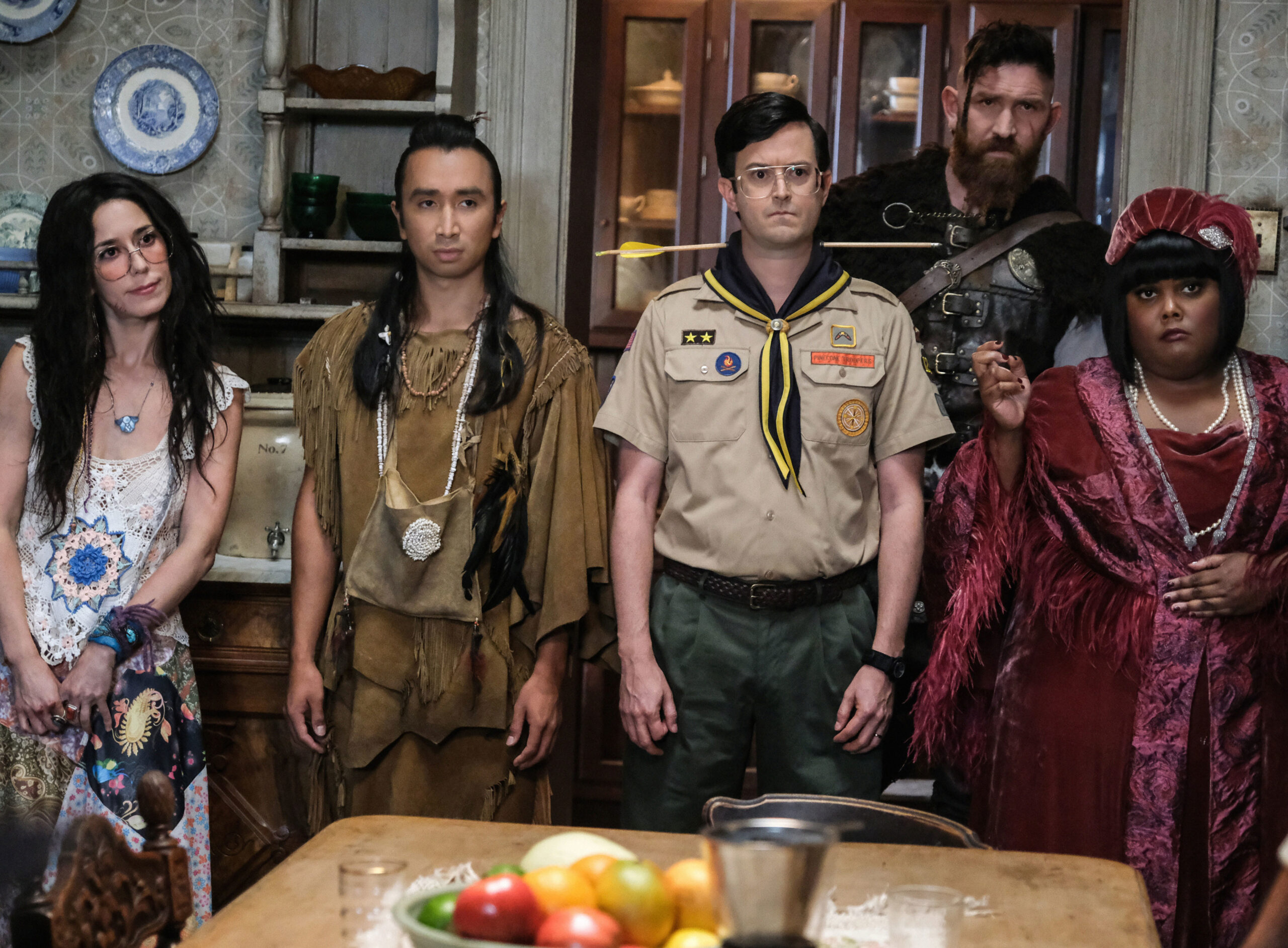 The cast of Ghosts US stand in a modern kitchen