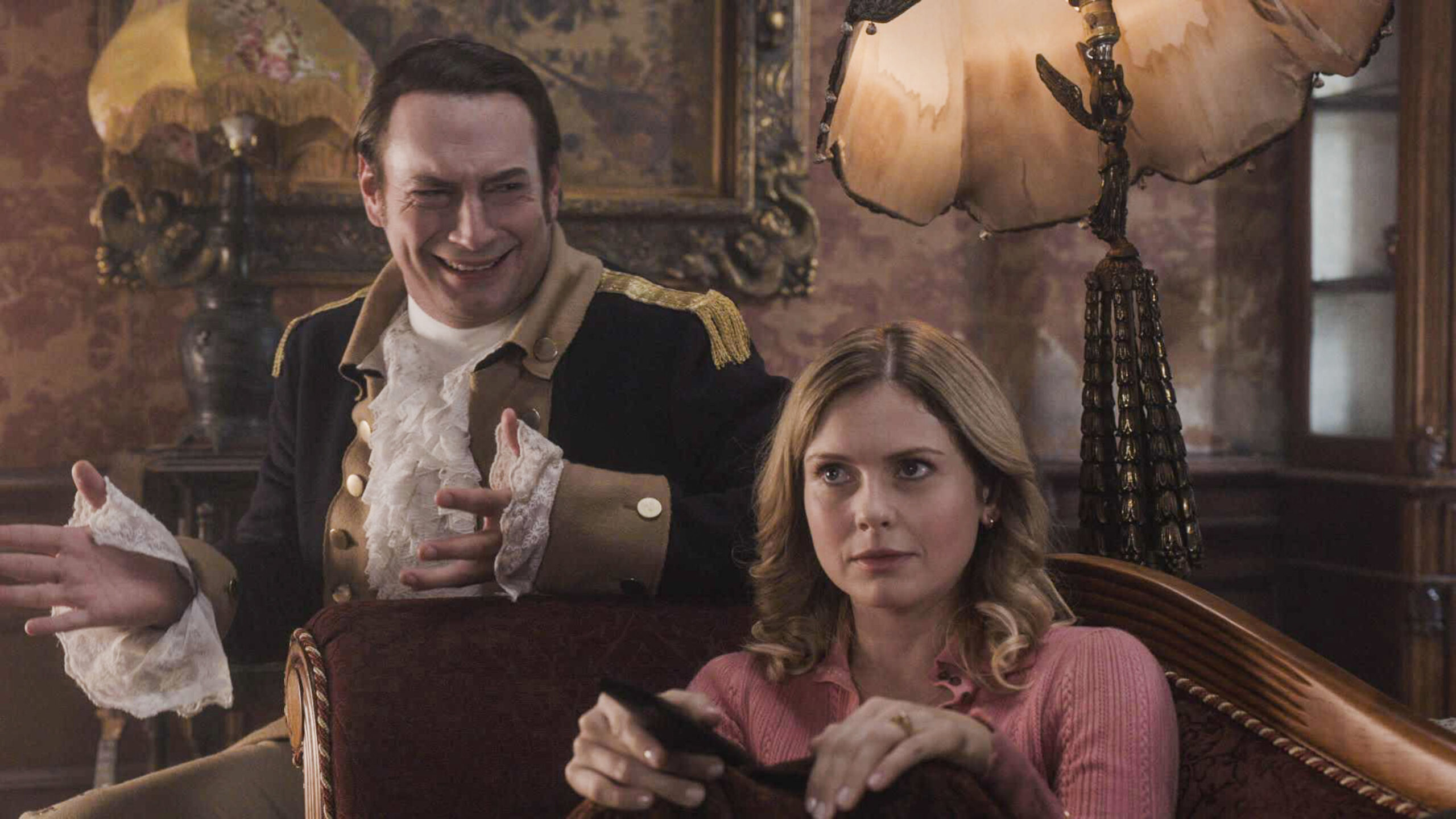 Isaac bothers Sam on the sofa in Ghosts US