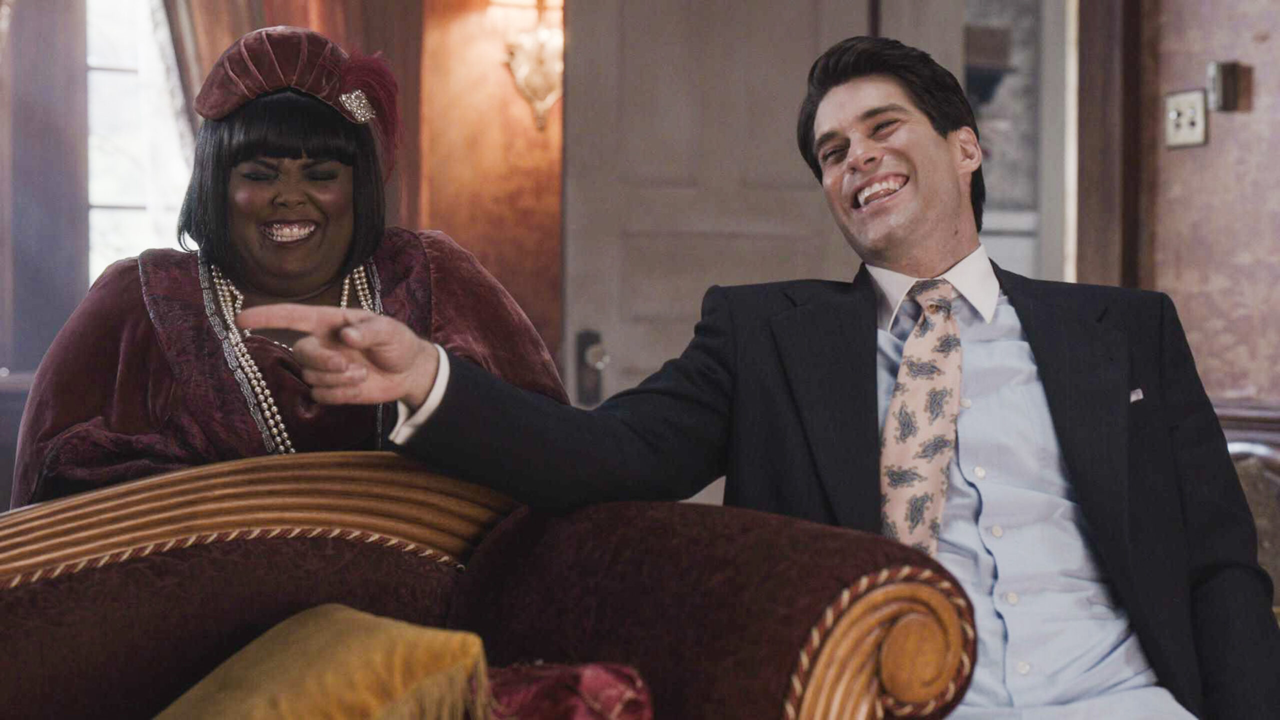 Trevor laughs on the sofa with Alberta next to him