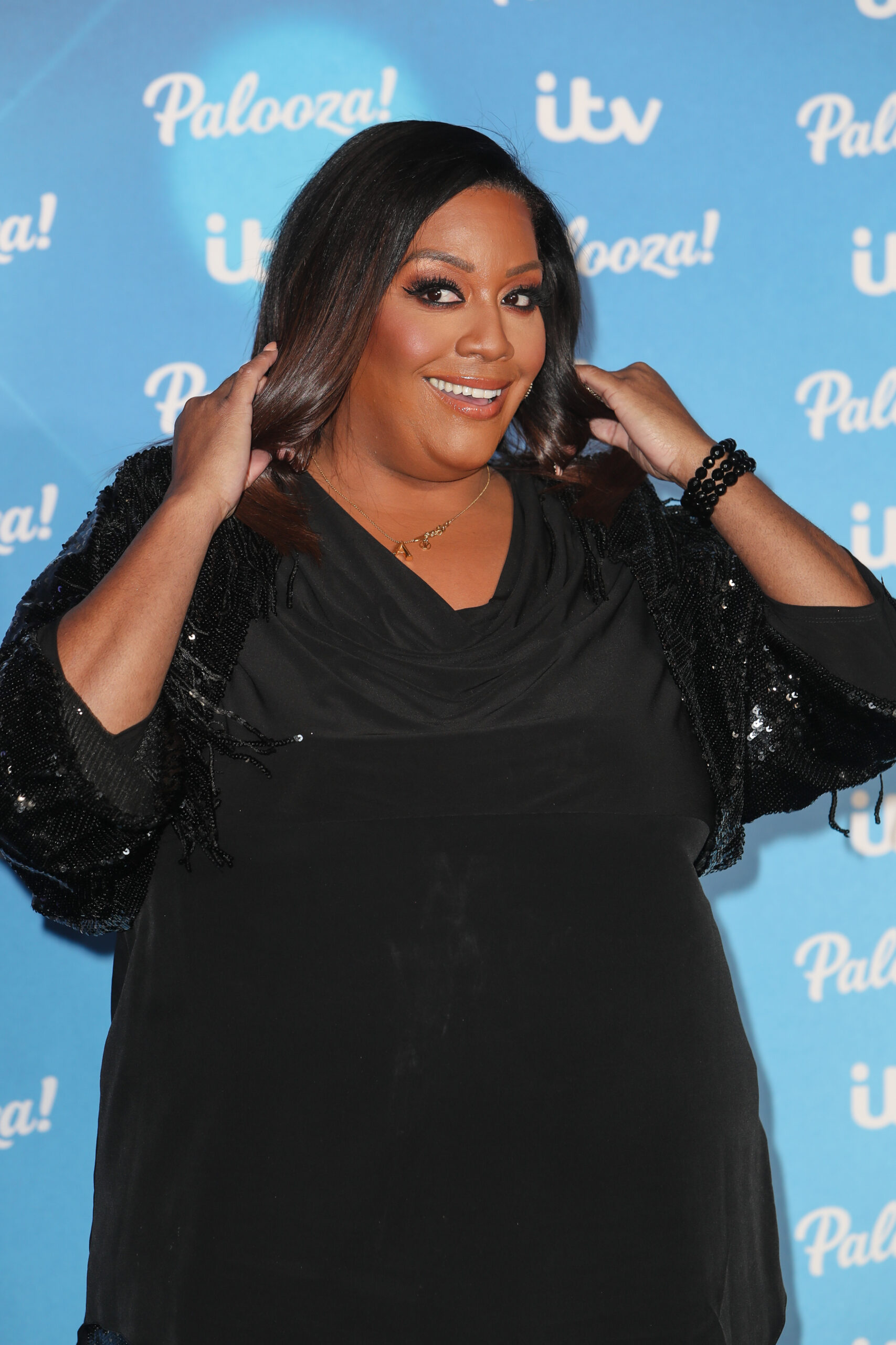 Alison Hammond smiling against a blue backdrop