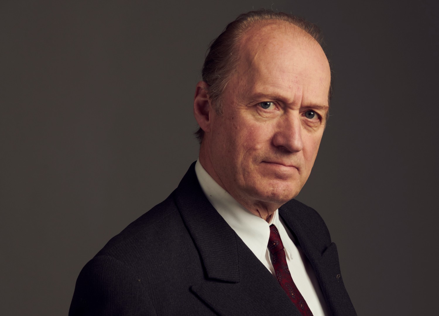 Adrian Edmondson in character as Sir Roger Hollis