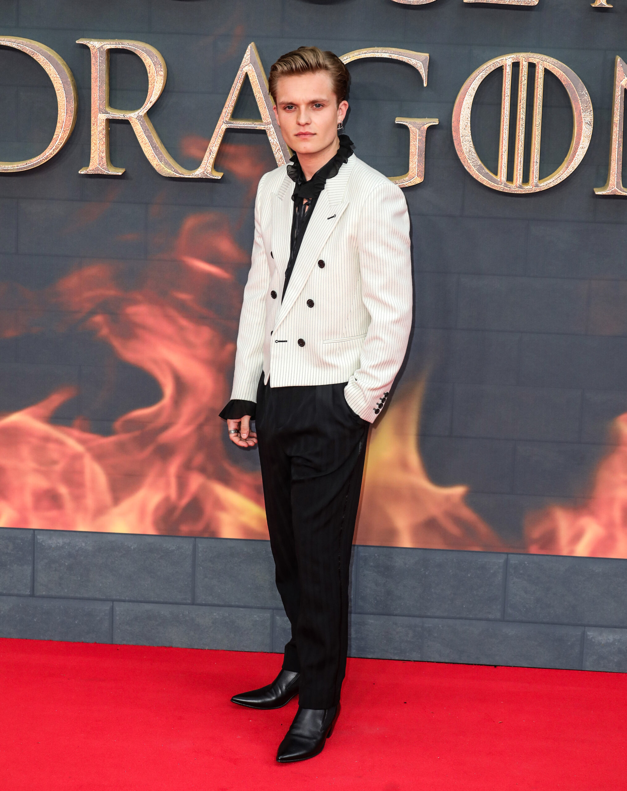 Tom Glynn-Carney in white blazer attends House of the Dragon red carpet event