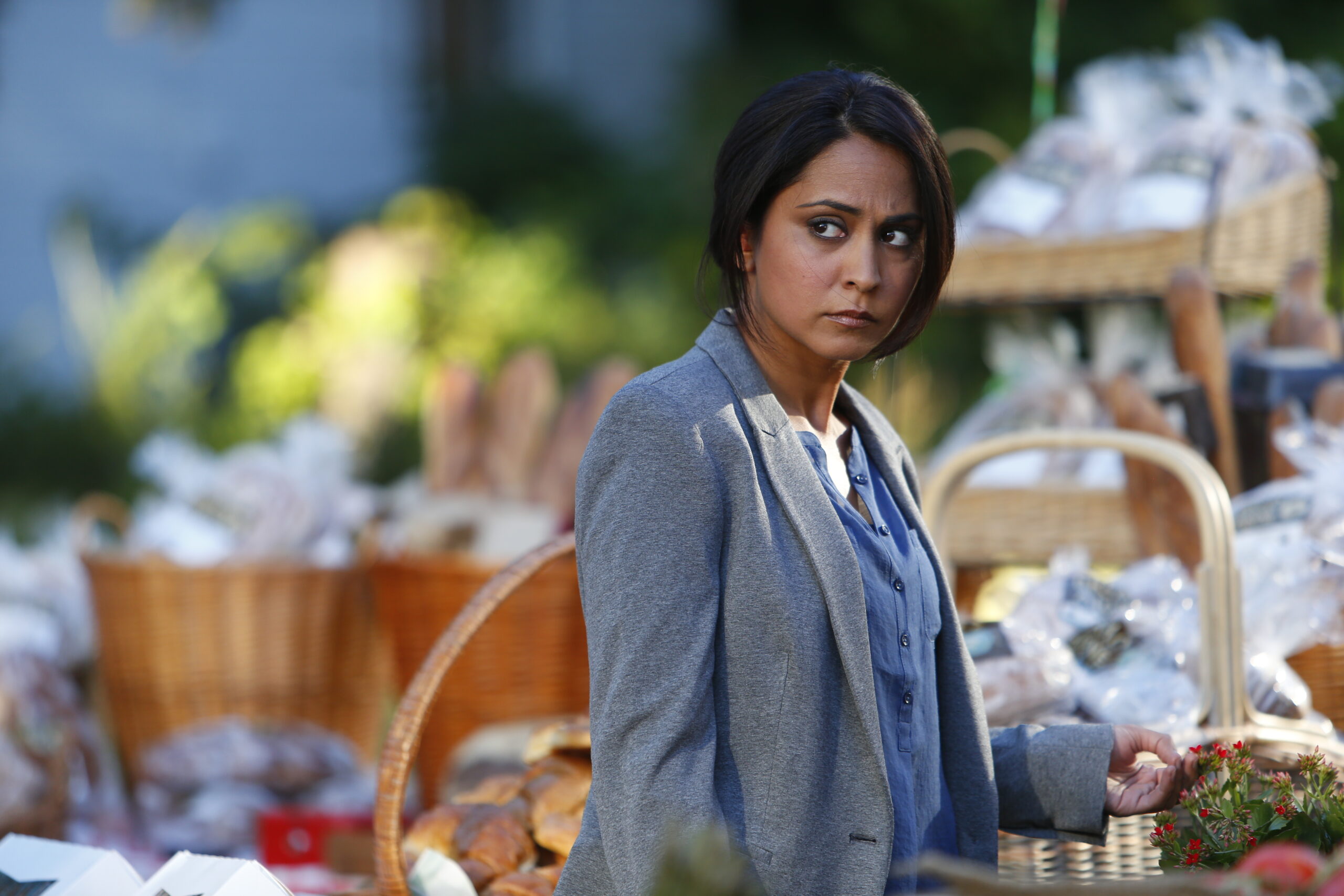Meera walks through a market in The Blacklist