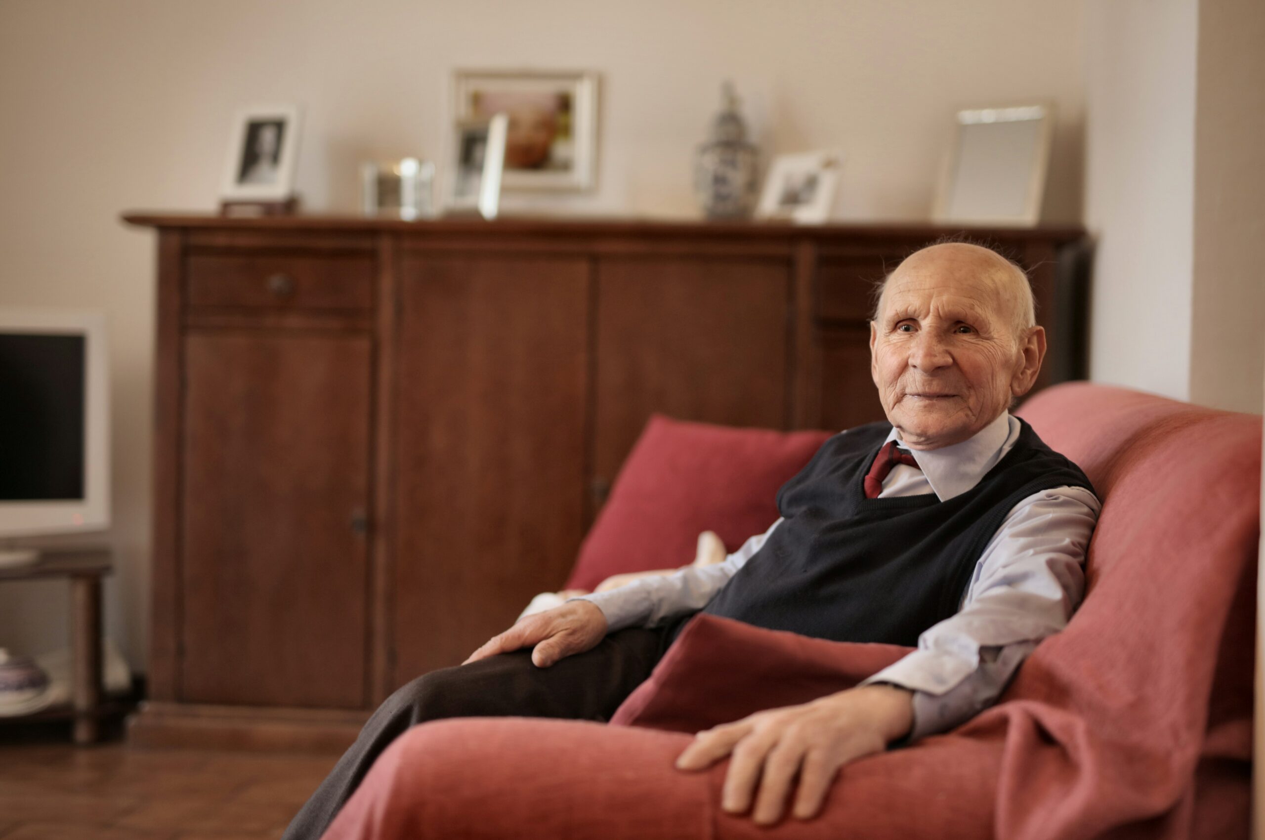 Elderly man alone sitting in armchair