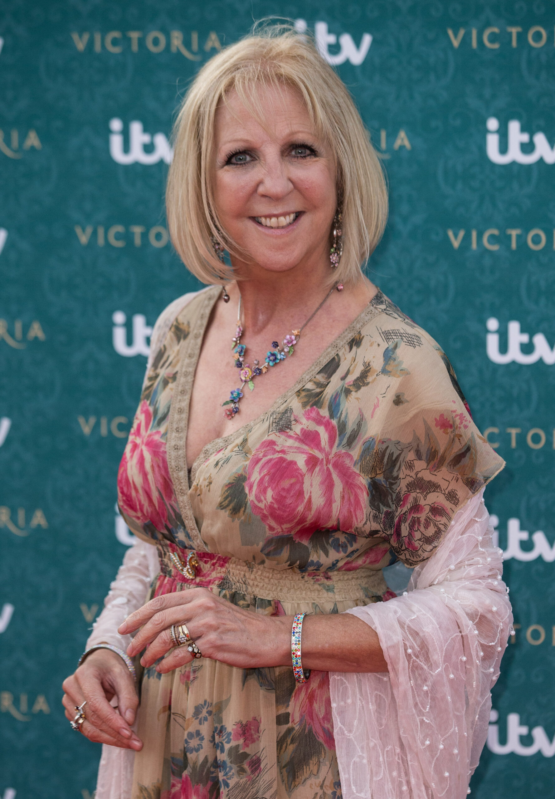 Nichola McAuliffe smiles in floral dress at red carpet event