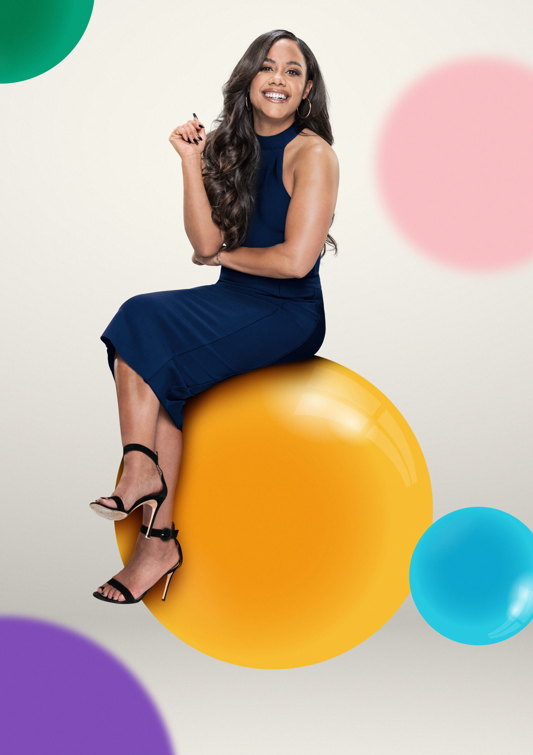 Alex Scott sitting on a yellow ball