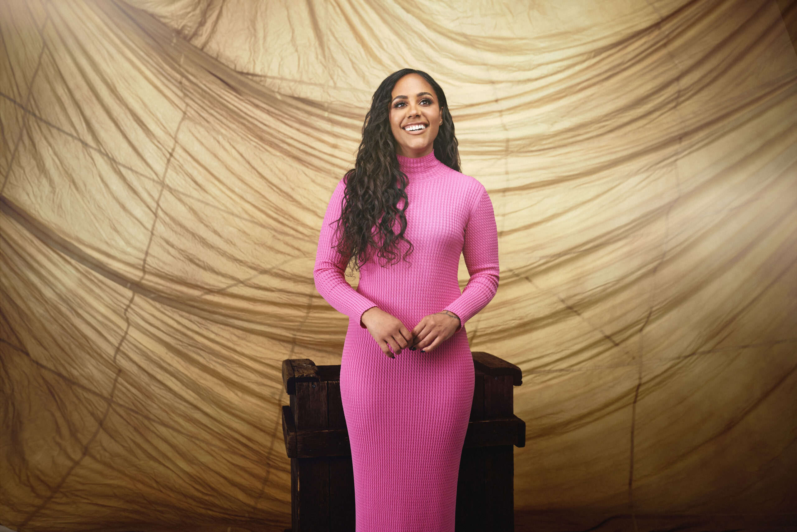 Alex Scott smiling wearing bright pink