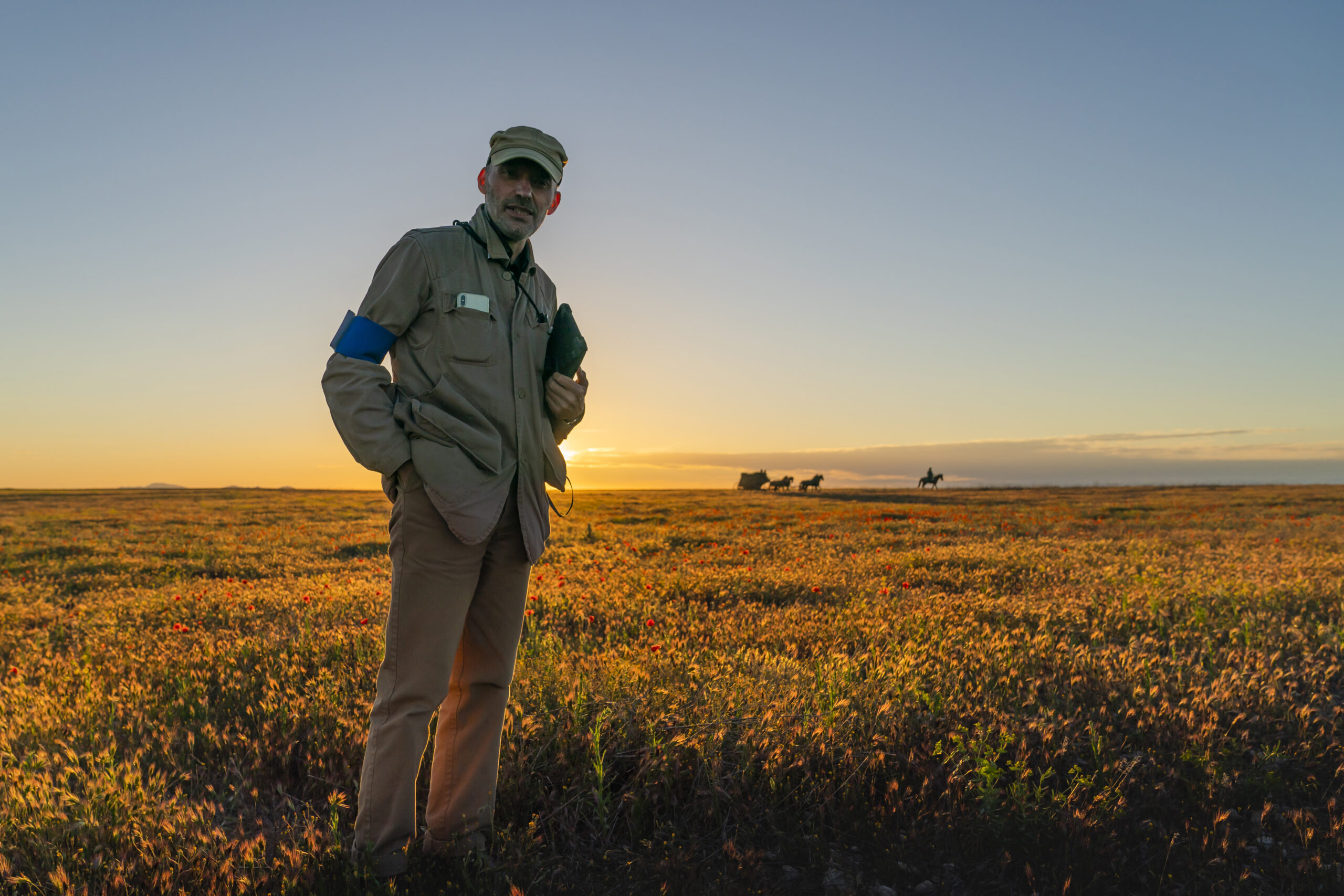 Hugo Blick stands in a field on the set of The English
