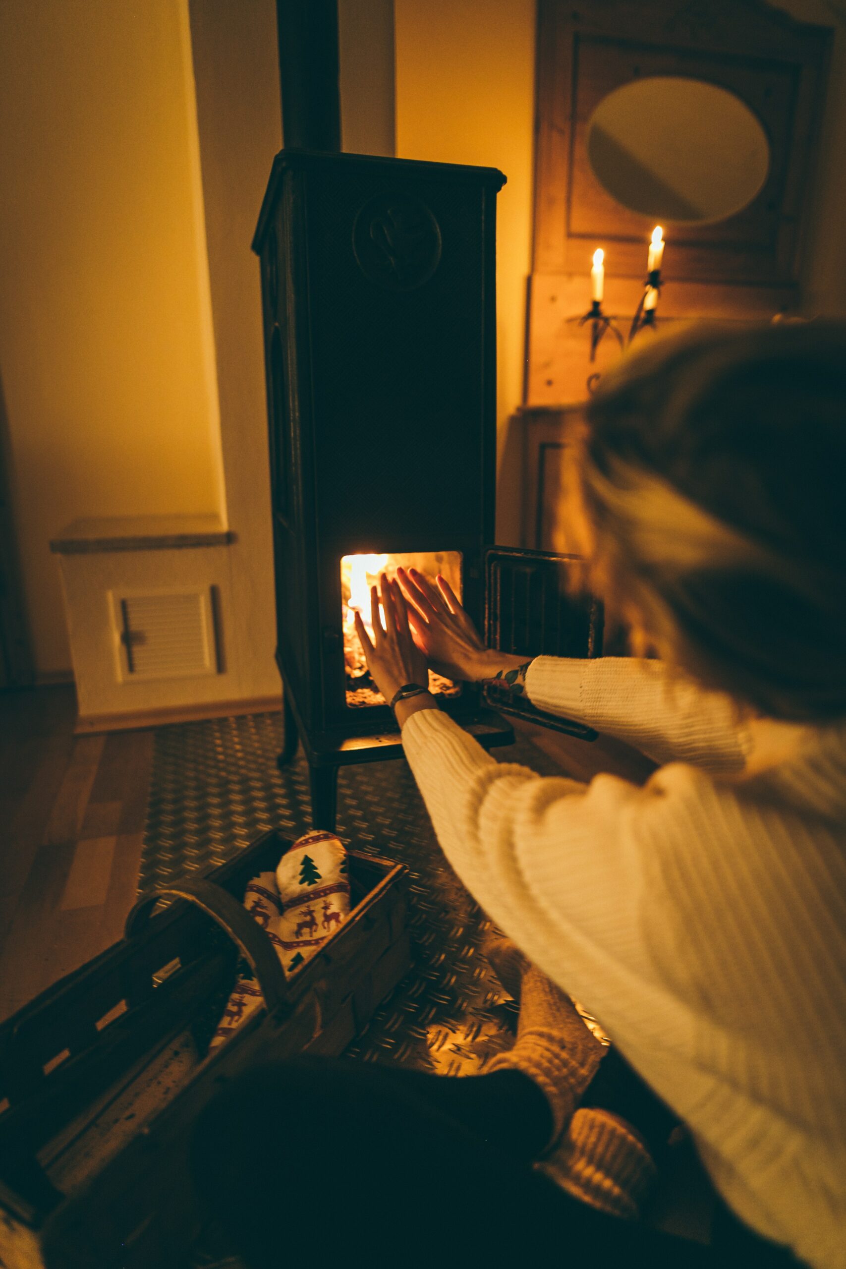 A woman holding her hands up to the fire to keep warm