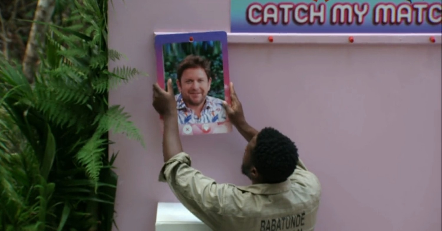 Babatunde Aleshe holding a picture of James Martin on I'm A Celebrity 2022 