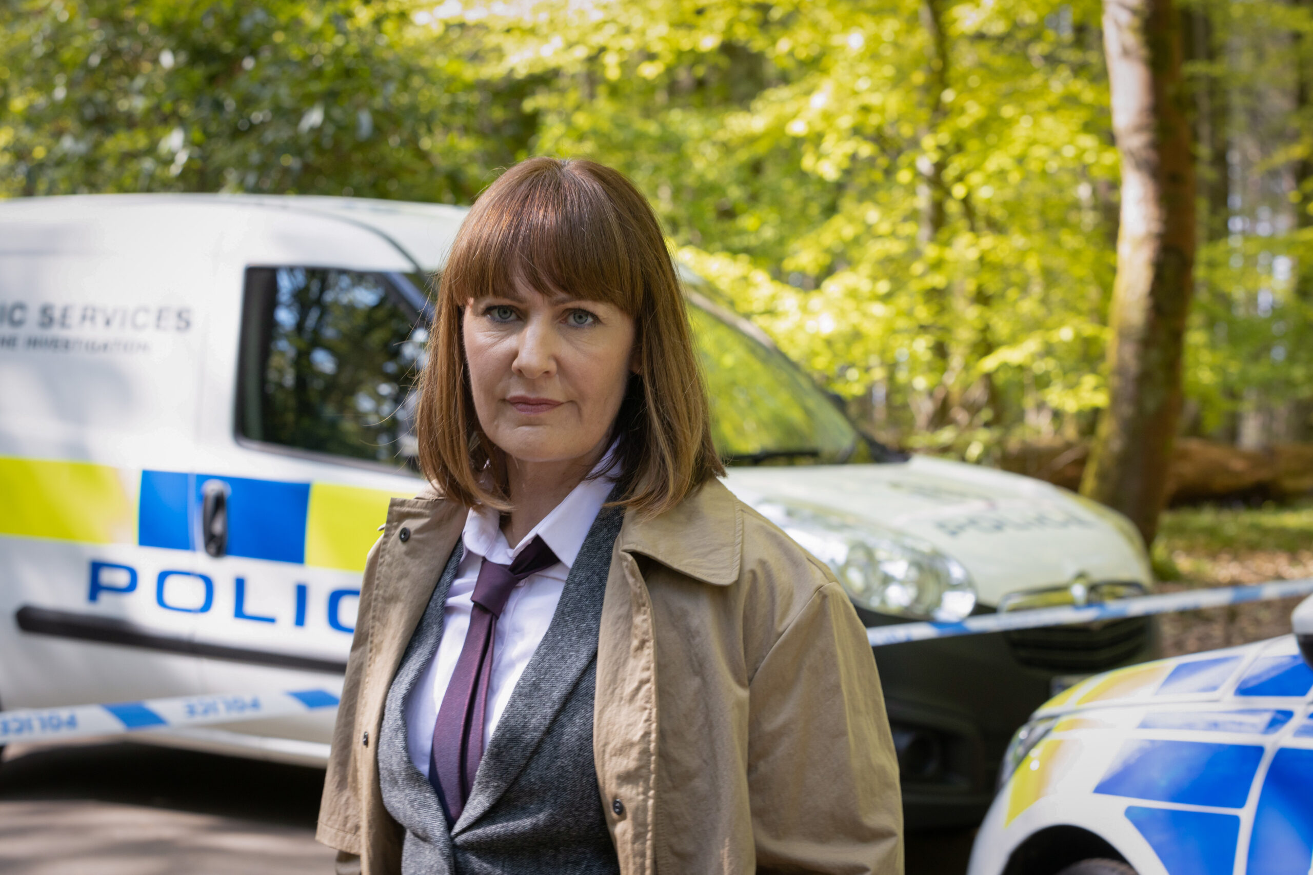 Monty stands next to a police van