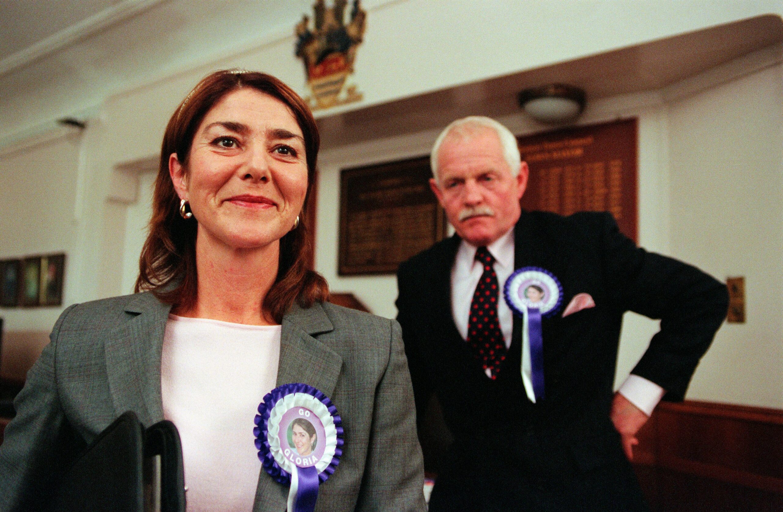 Gloria Pollard looks proud in an election rosette while husband Eric scowls behind her