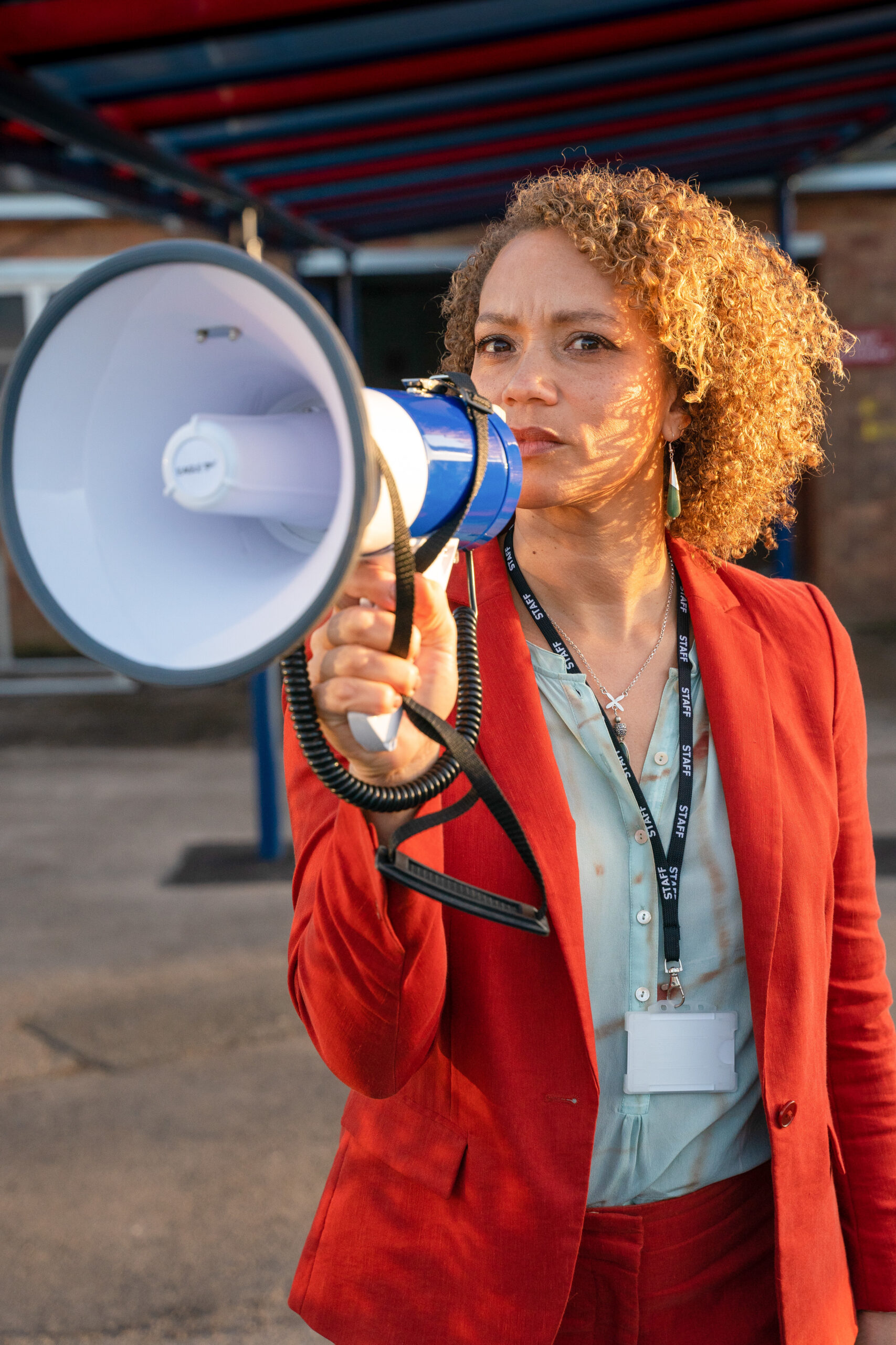 Kim Cambell holding up a bullhorn looking serious is Waterloo Road