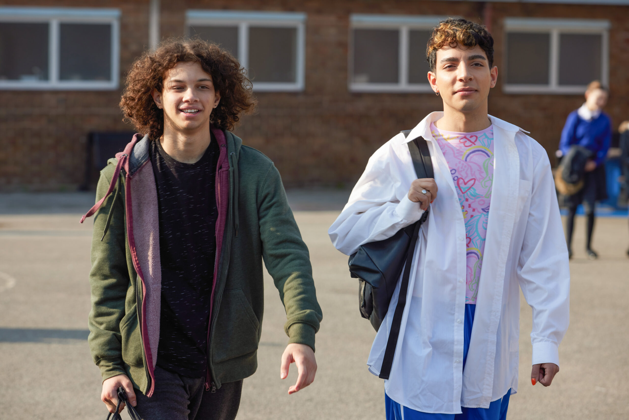 Danny and Kai smiling as they walk through the Waterloo Road playground 