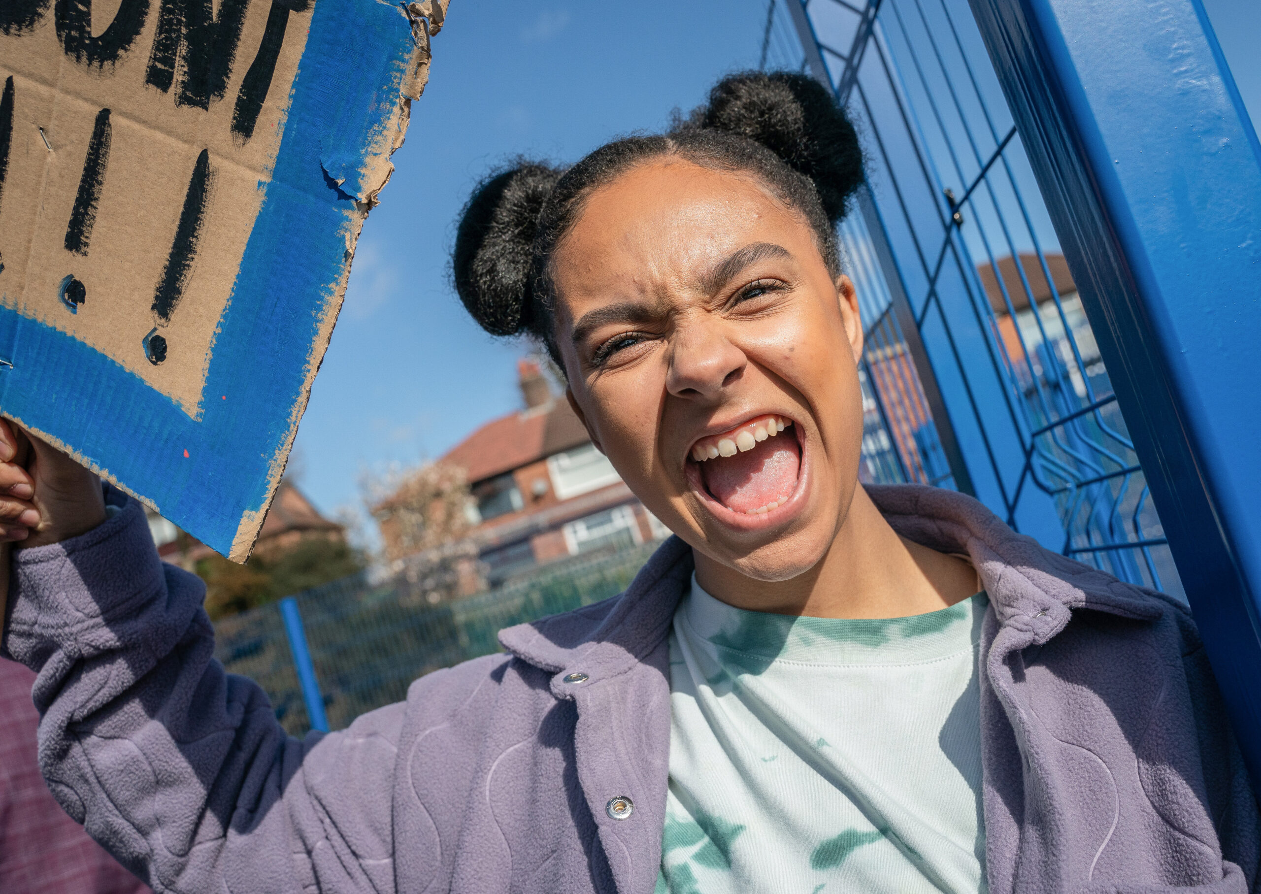 Kelly Jo Rafferty smiling as she holds a sign in Waterloo Road