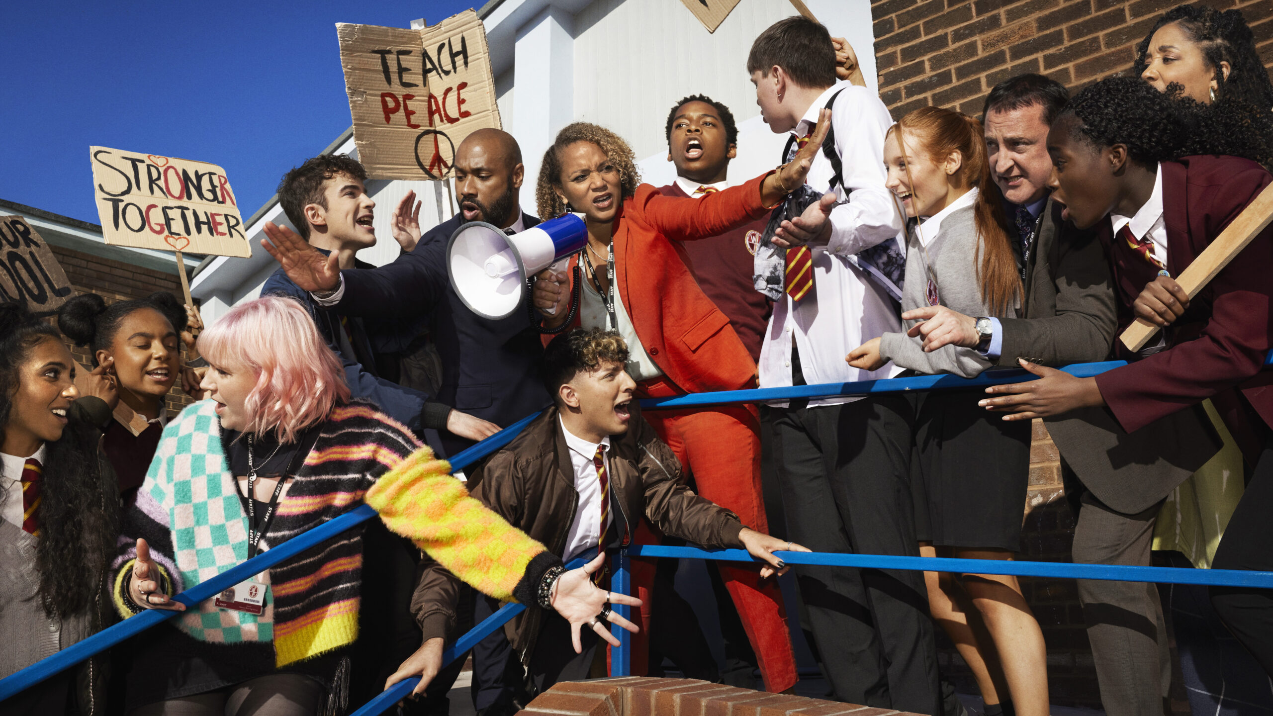 The students of Waterloo Road are protesting outside as the staff try to calm them down with a megaphone