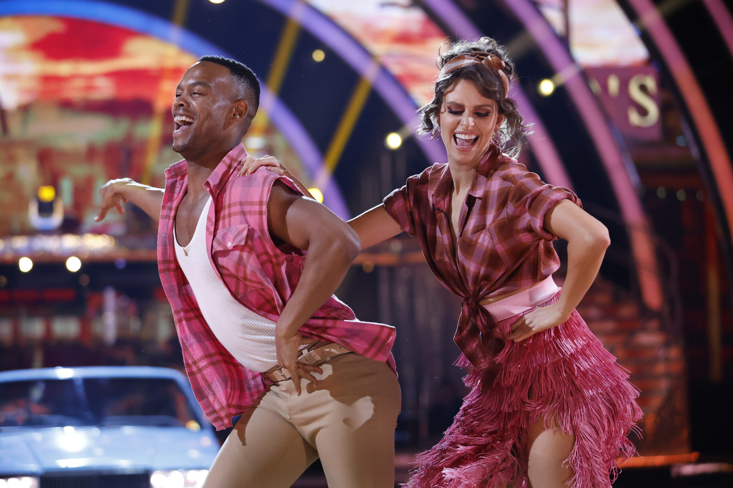 Johannes and Ellie smile as they perform a jive