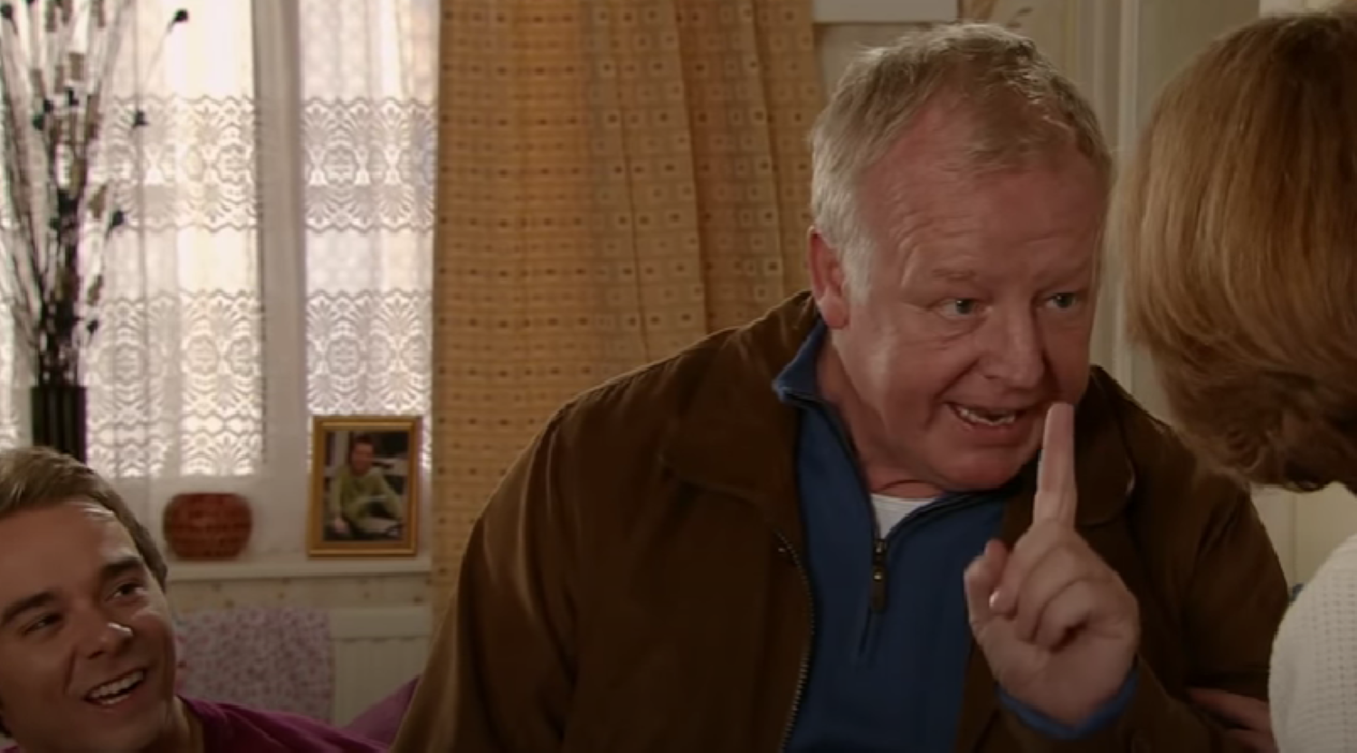 Michael shushing Gail as David laughs in Coronation Street