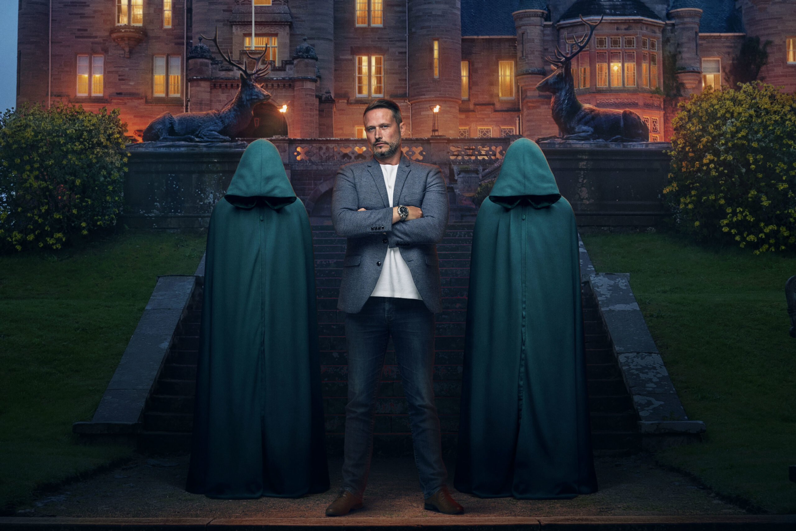 Contestant Kieran smiles between The Traitors