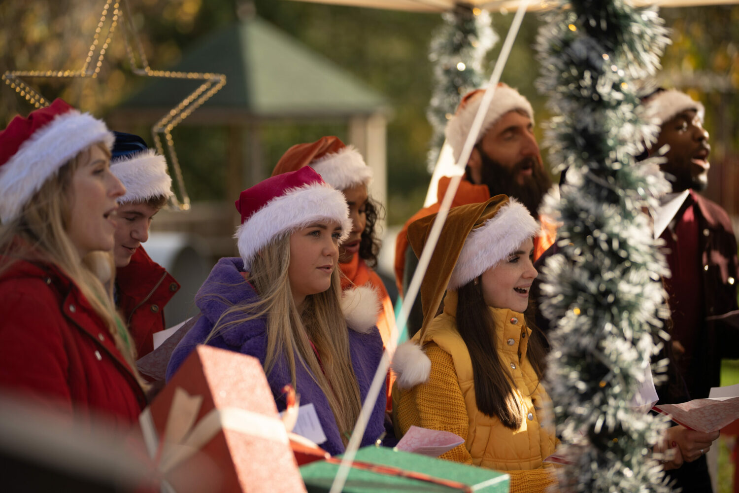Emmerdale's Cathy is wearing a Santa hat and is singing at the carol concert