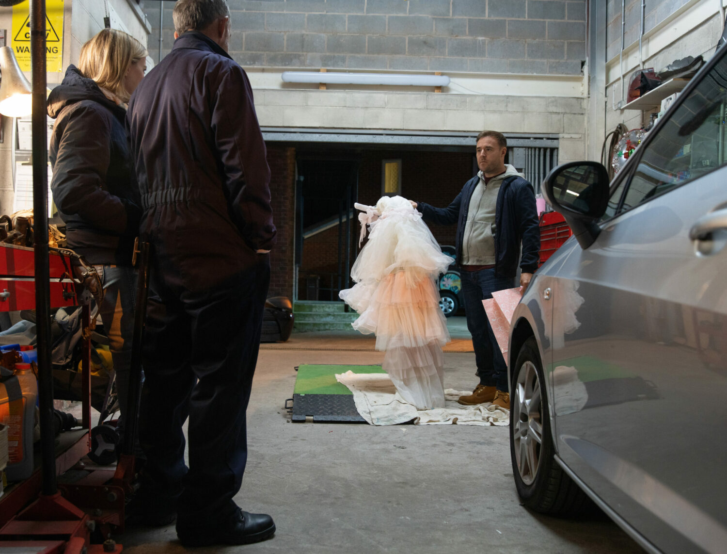 Tyrone looks unimpressed as he shows a wedding dress to Abi and Kevin on Corrie
