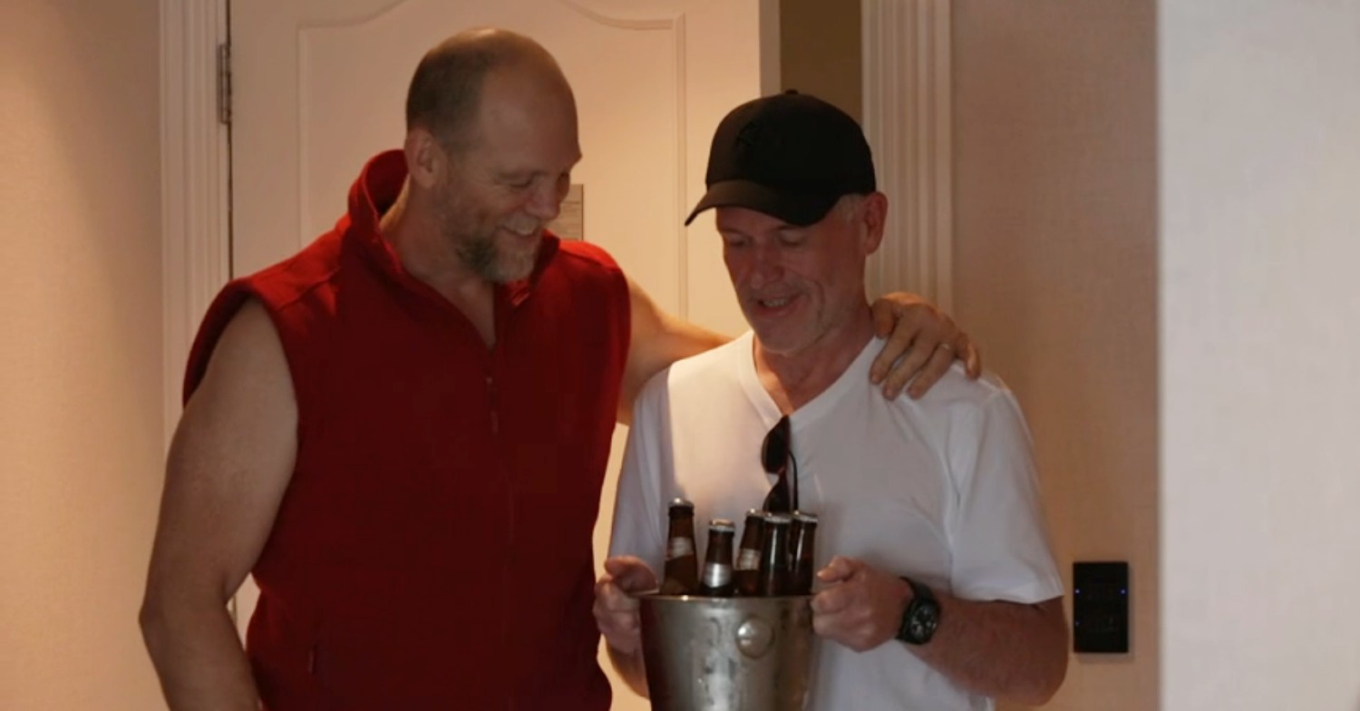 I'm A Celebrity star Mike Tindall with his arm round Chris Moyles, who's carrying a bucket of beers 