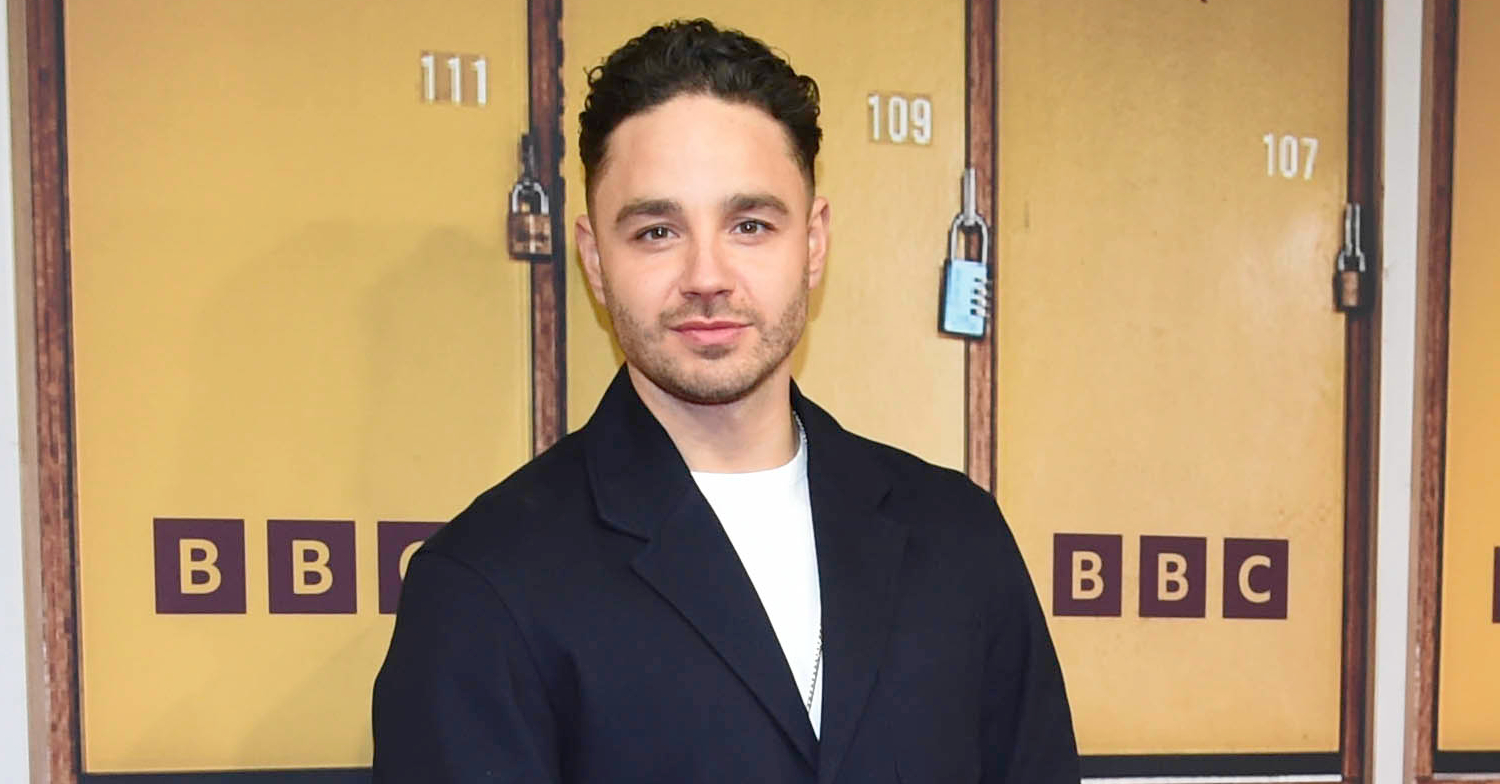 Adam Thomas is posing on the red carpet for a Waterloo Road press event