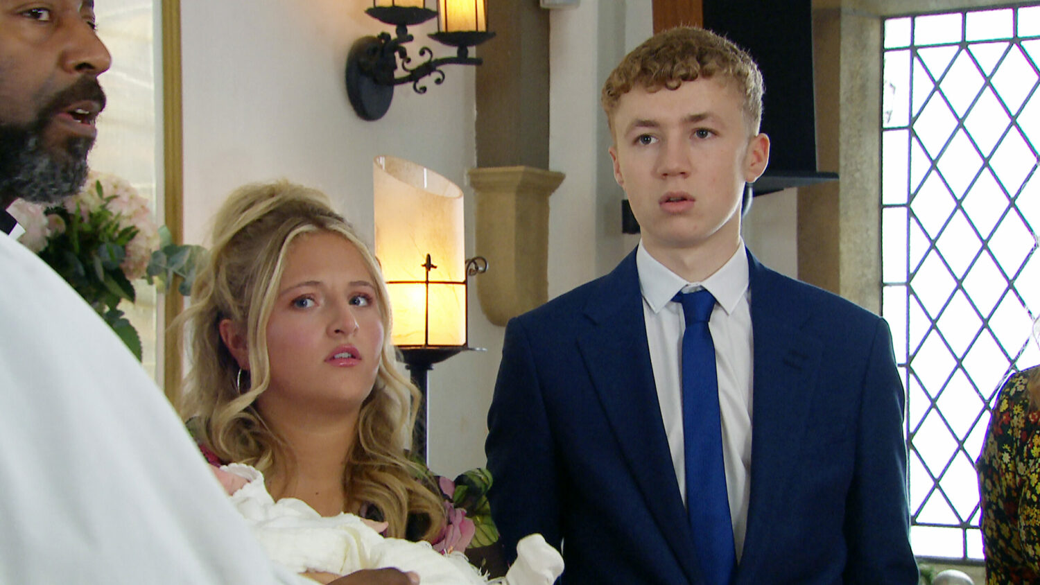 Emmerdale's Amelia is holding baby Esther whilst standing next to Noah