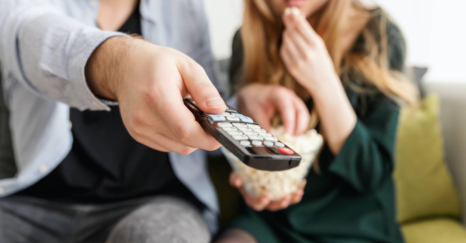 A man uses a remote control to switch off Christmas Day TV