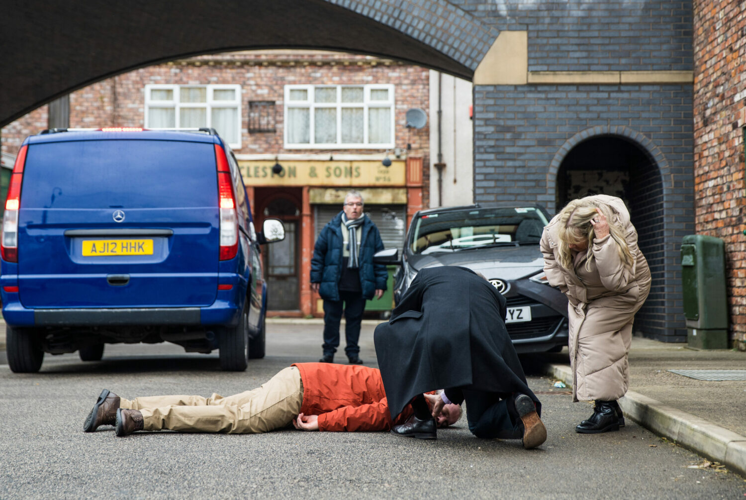 Teddy lies in the street as people try to help him in Corrie 