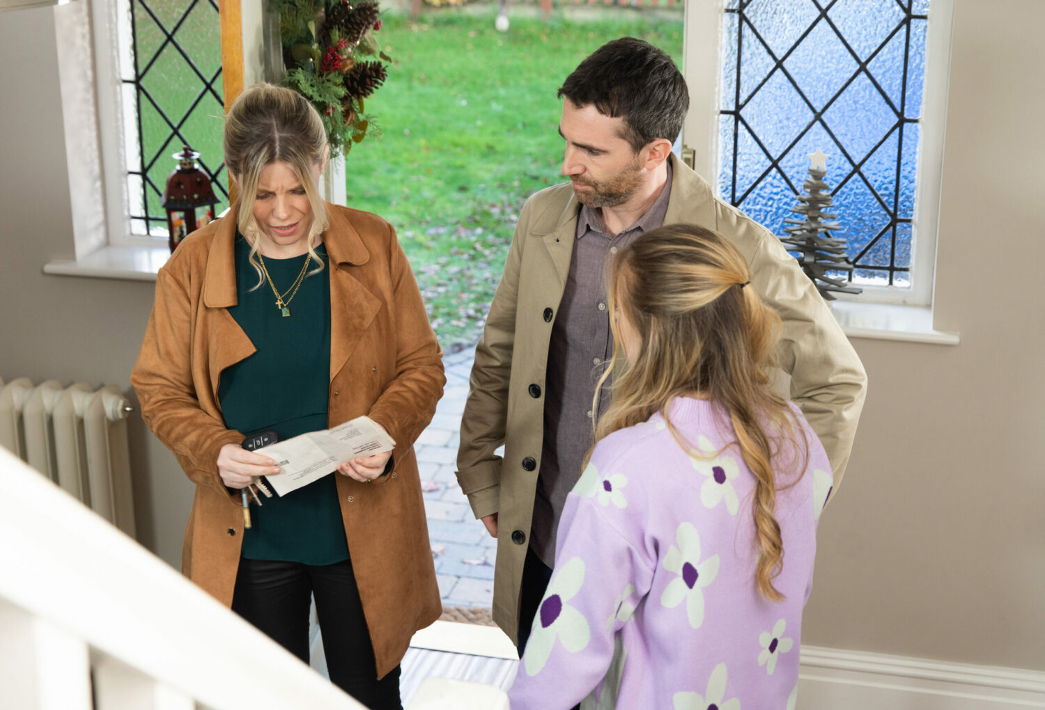 Esther looking at a piece of paper as Mike and Summer look worried in Coronation Street 