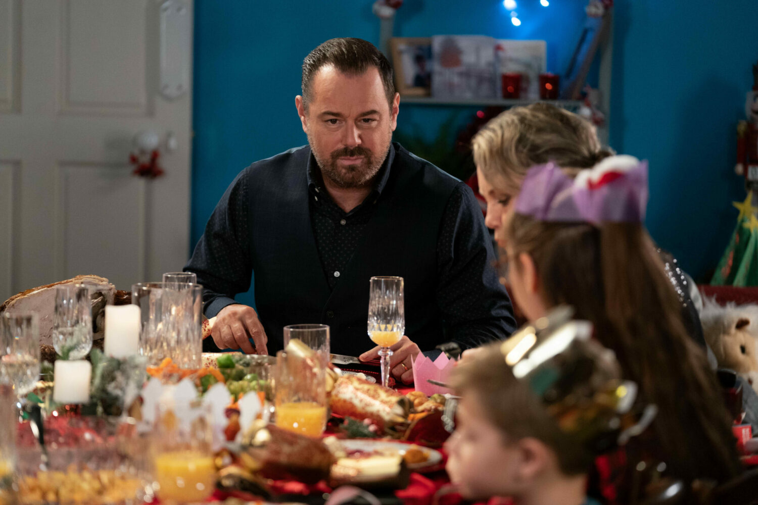 Mick sits at the dinner table, looking unhappy next to Janine and the kids on EastEnders 
