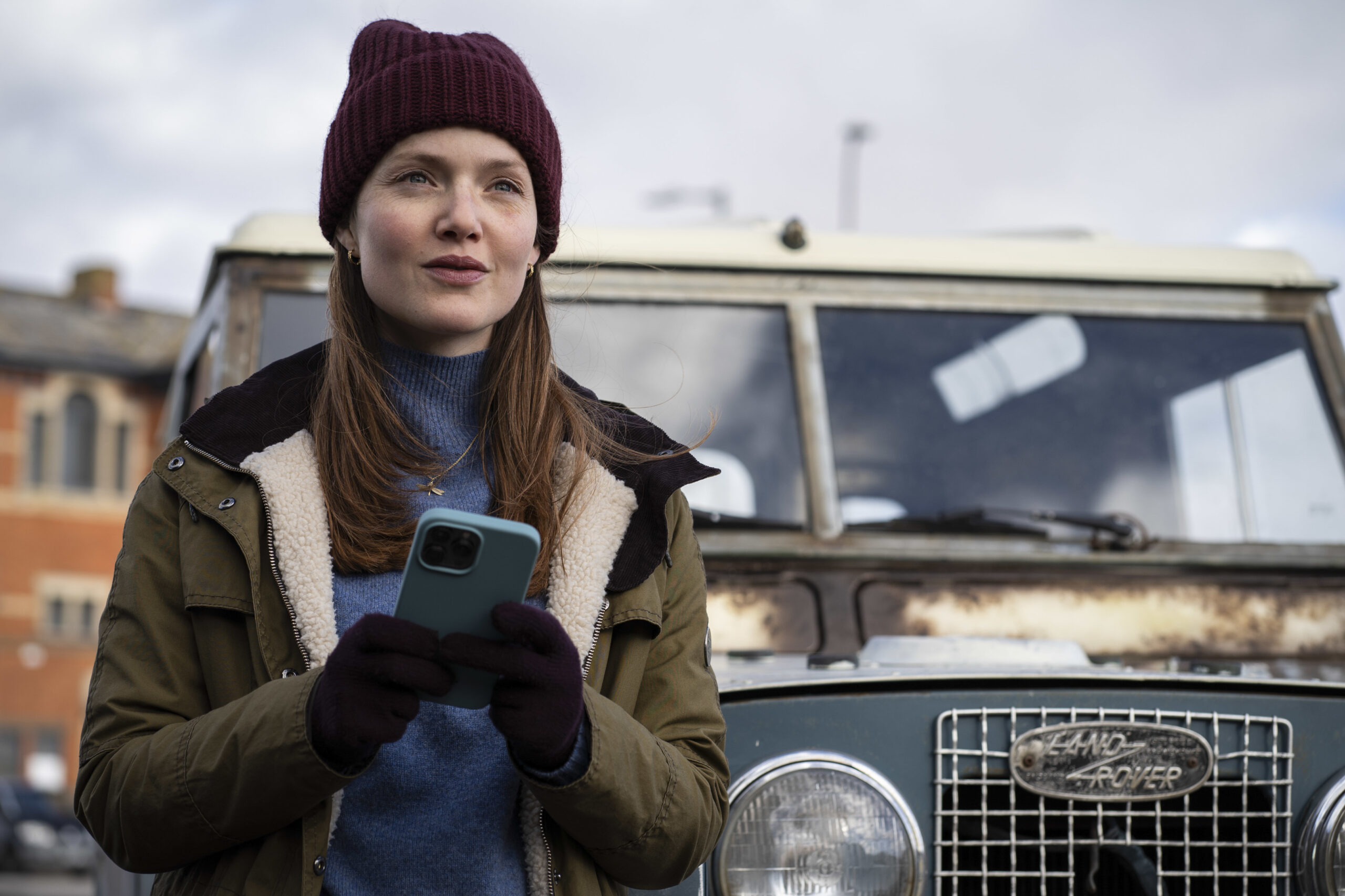 Robin Ellacott holds her phone outside in Strike Troubled Blood