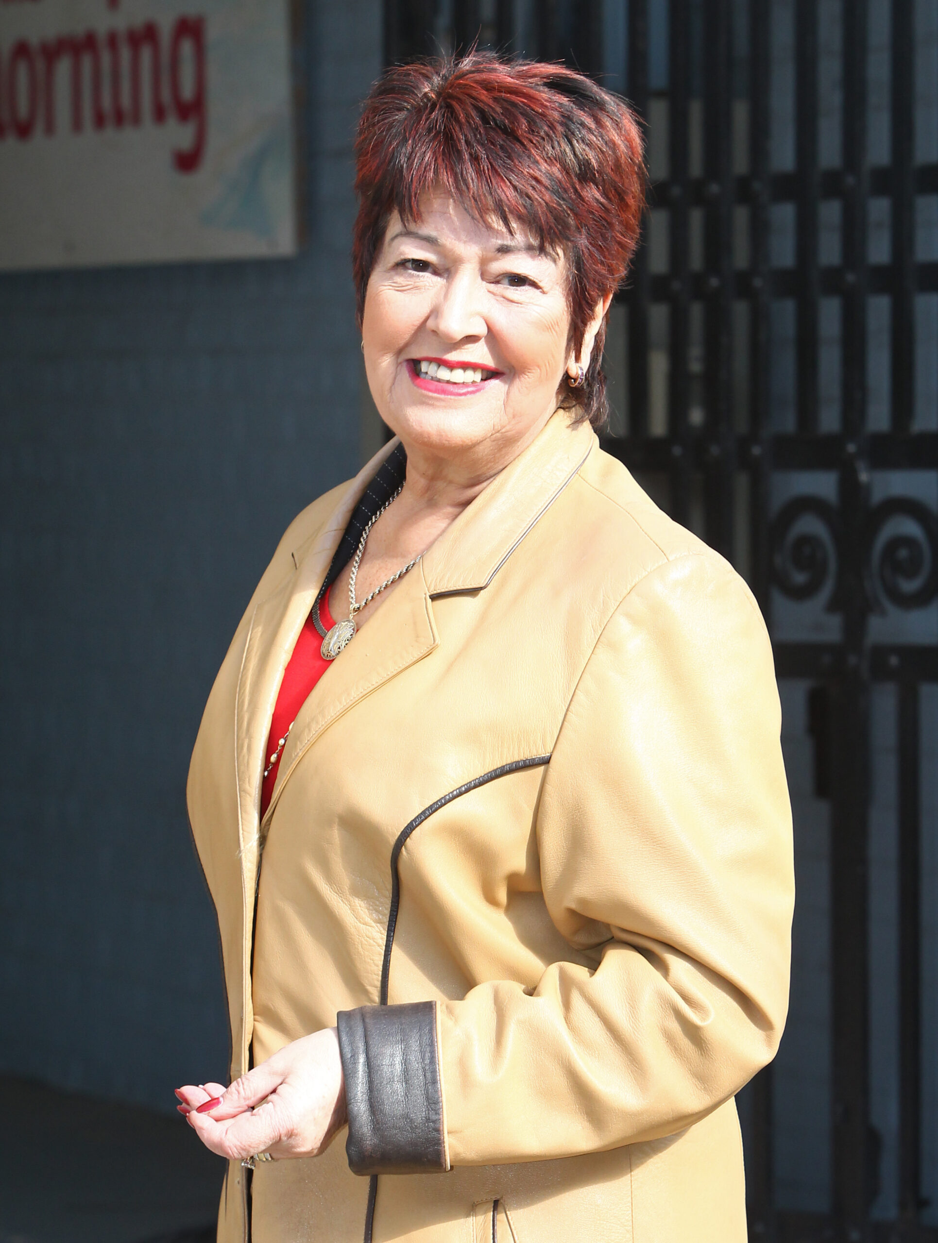 Ruth Madoc smiling in a leather coat